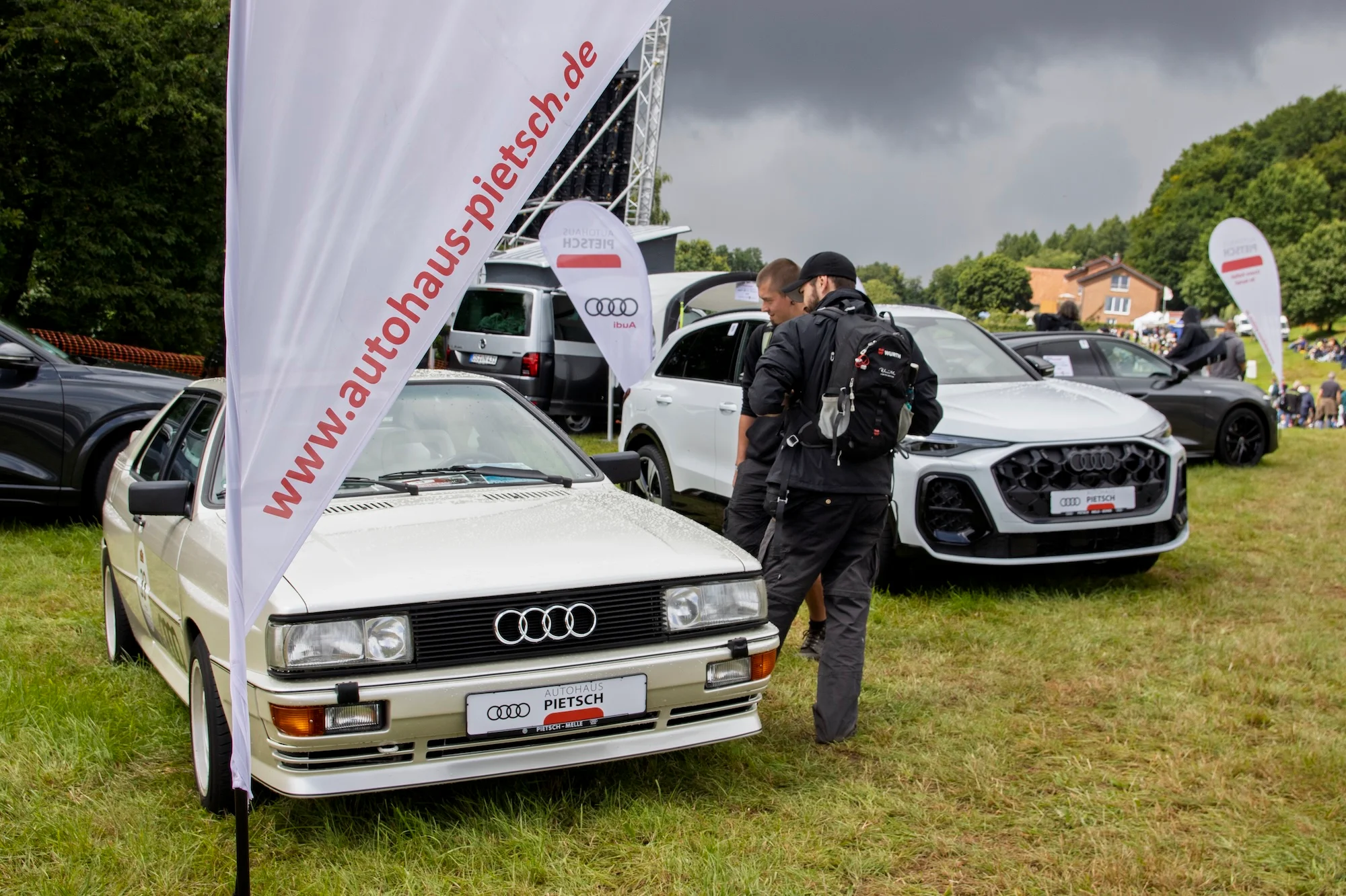 Fahrzeuge und Besucher des 57. Bergrennen auf einer Wiese an der Stecke