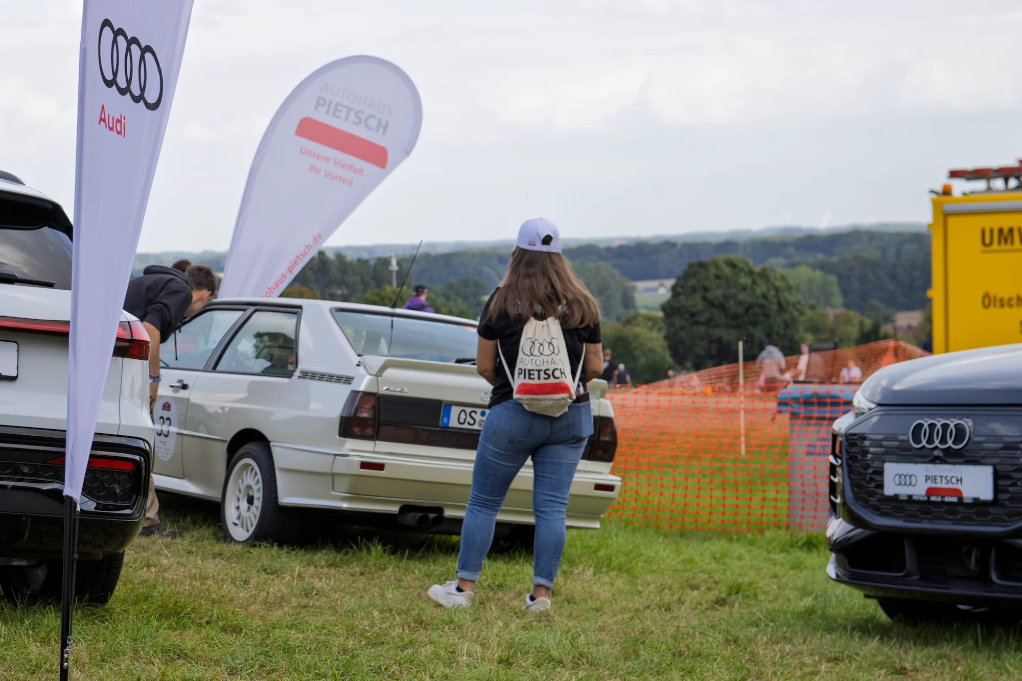 Fahrzeuge und Besucher des 57. Bergrennen auf einer Wiese an der Stecke