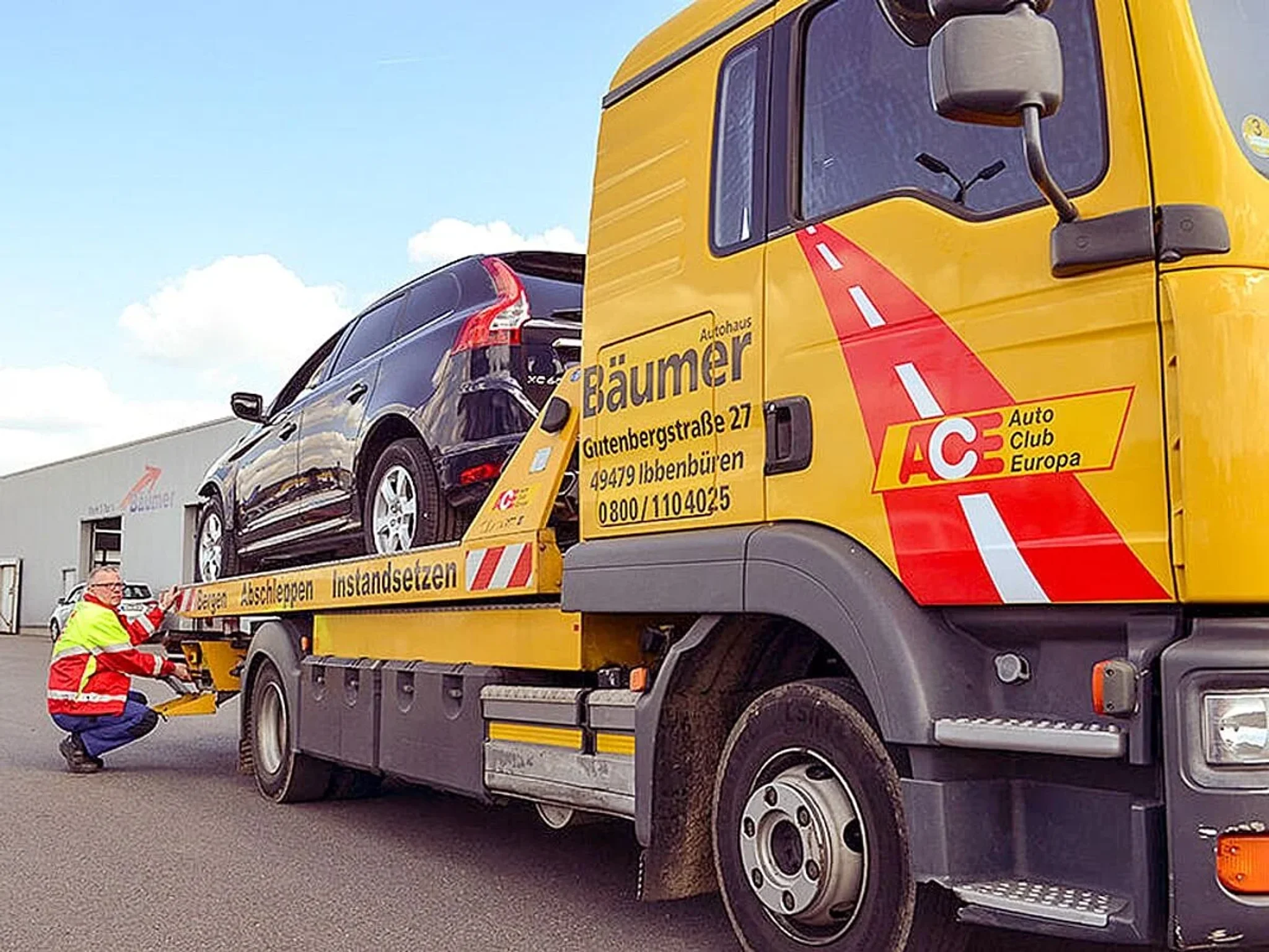 Abschleppwagen des Autohaus Bäumer, ein Mitarbeiter lädt ein Fahrzeug auf