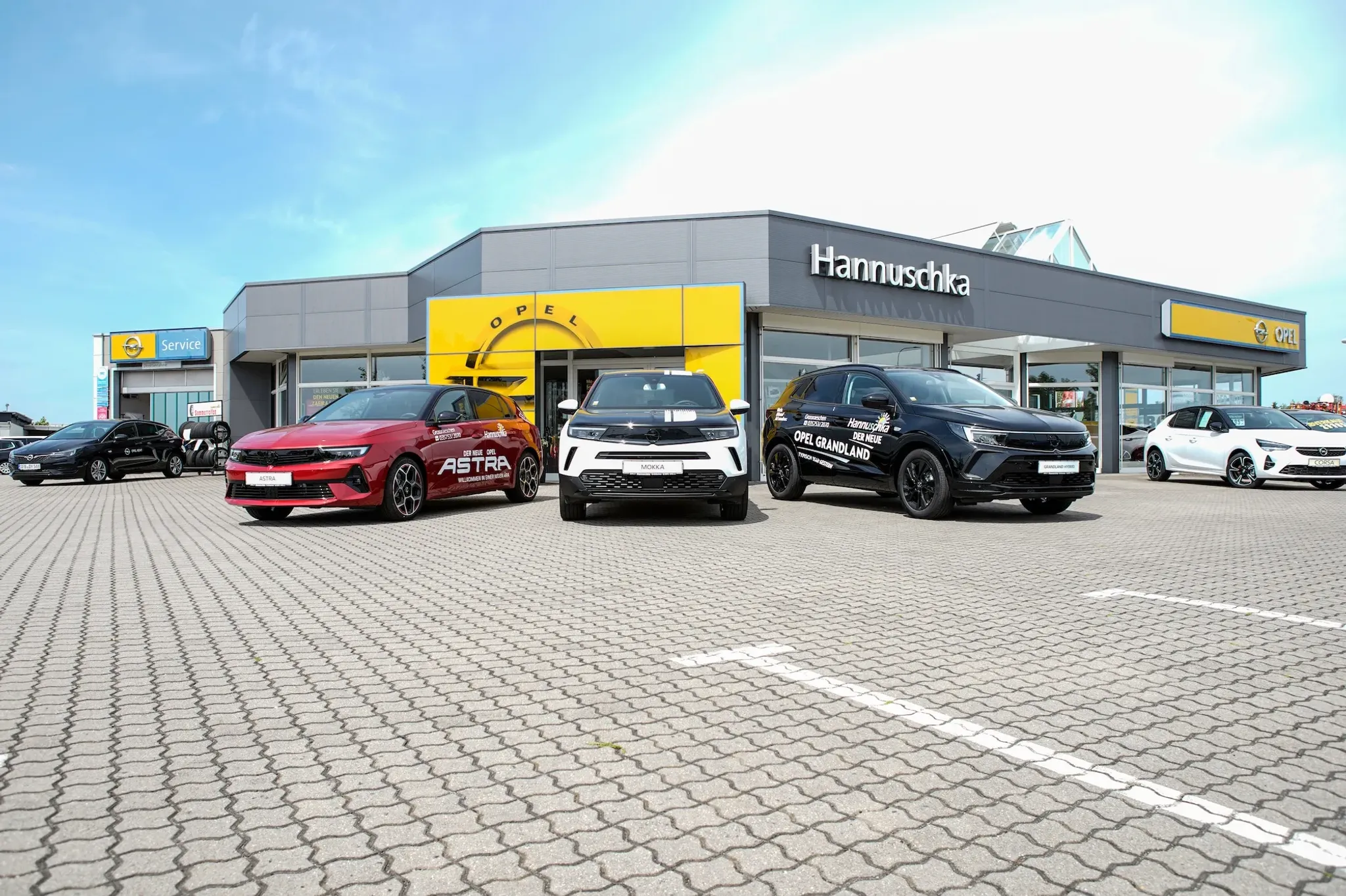 Autohaus Hannuschka fotografiert mit Weitwinkel von vorn Richtung Eingang und Hannuschka. Schriftzug am Dach.