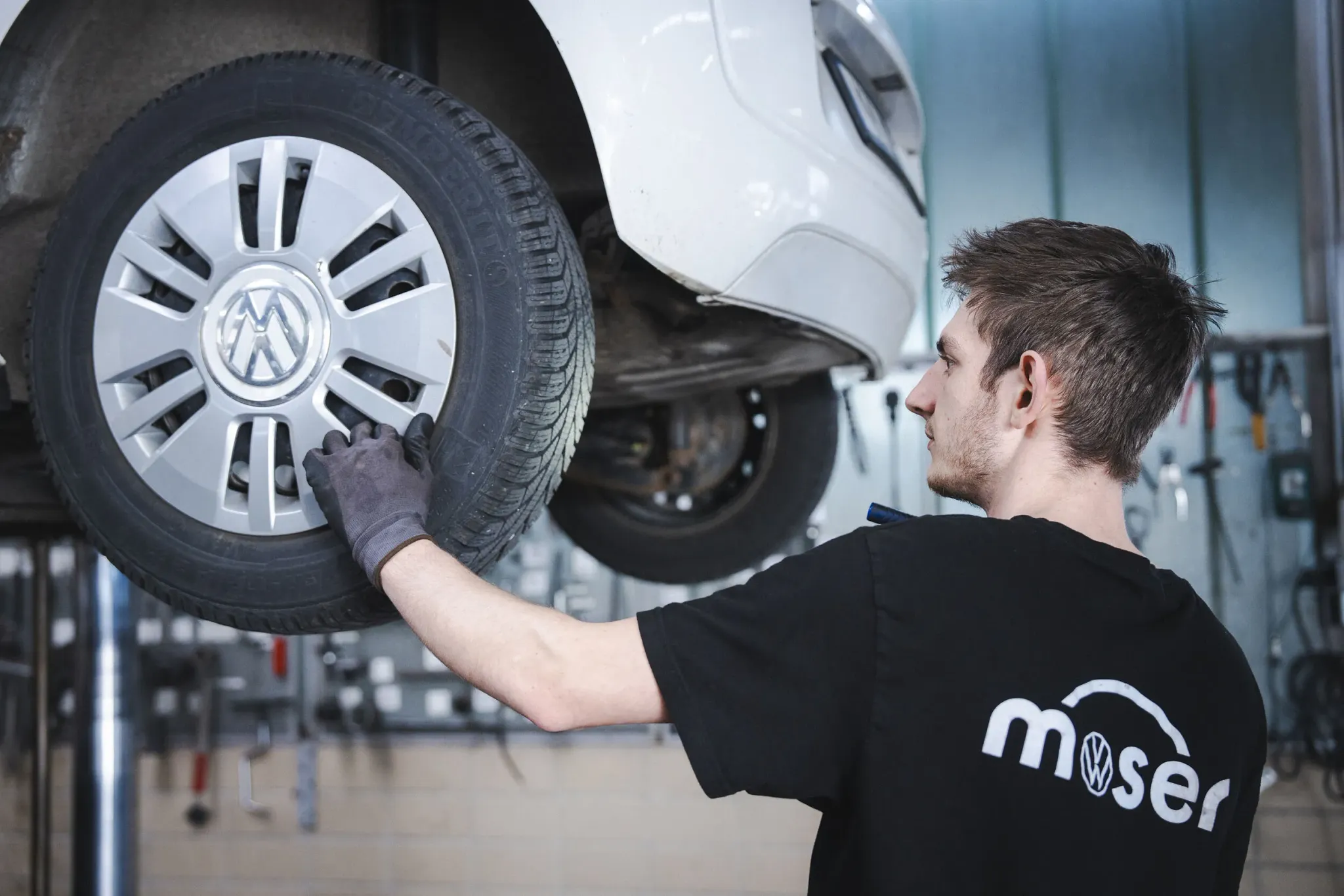 Mitarbeiter vom Autohaus Moser beim Räderwechsel an einem Fahrzeug, welches auf der Hebebühne steht