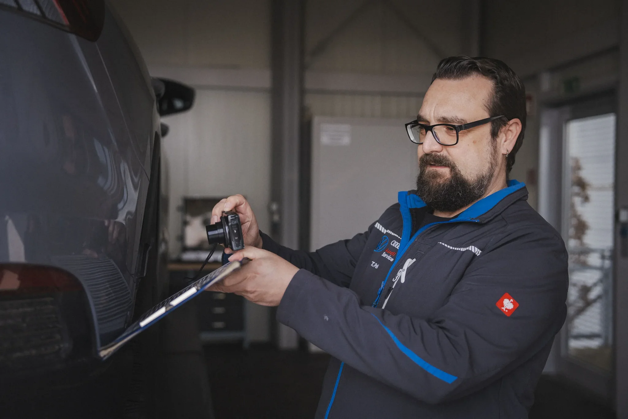 Mitarbeiter des Autohaus Moser bei der Begutachtung eines Fahrzeugs.