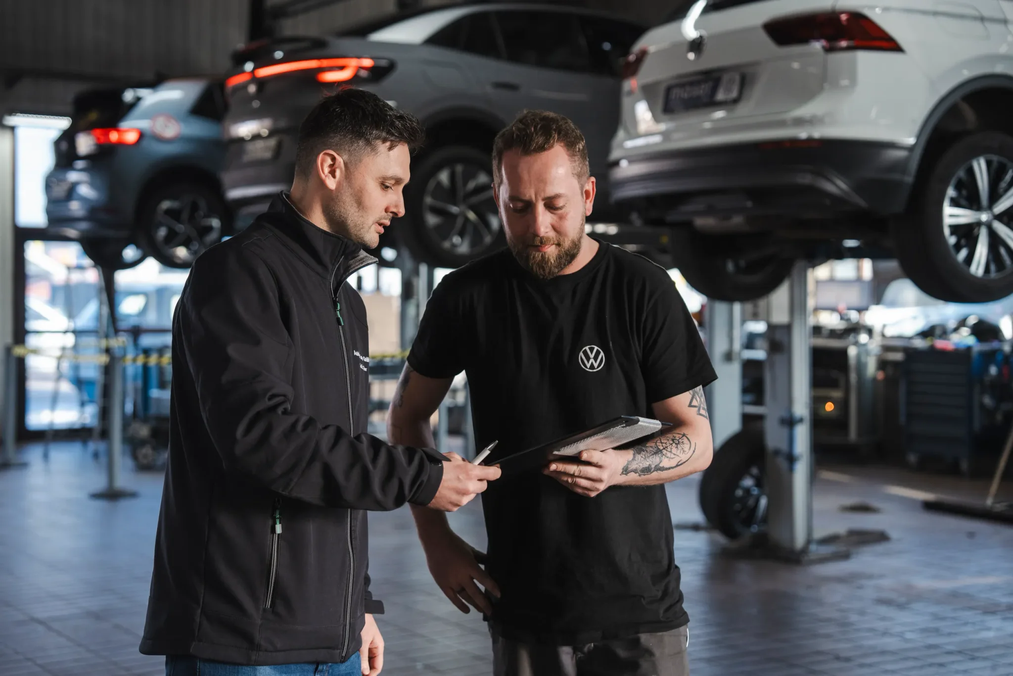 Zwei Service Mitarbeiter des Autohaus Moser in der Werkstatt beim Gedankenaustausch