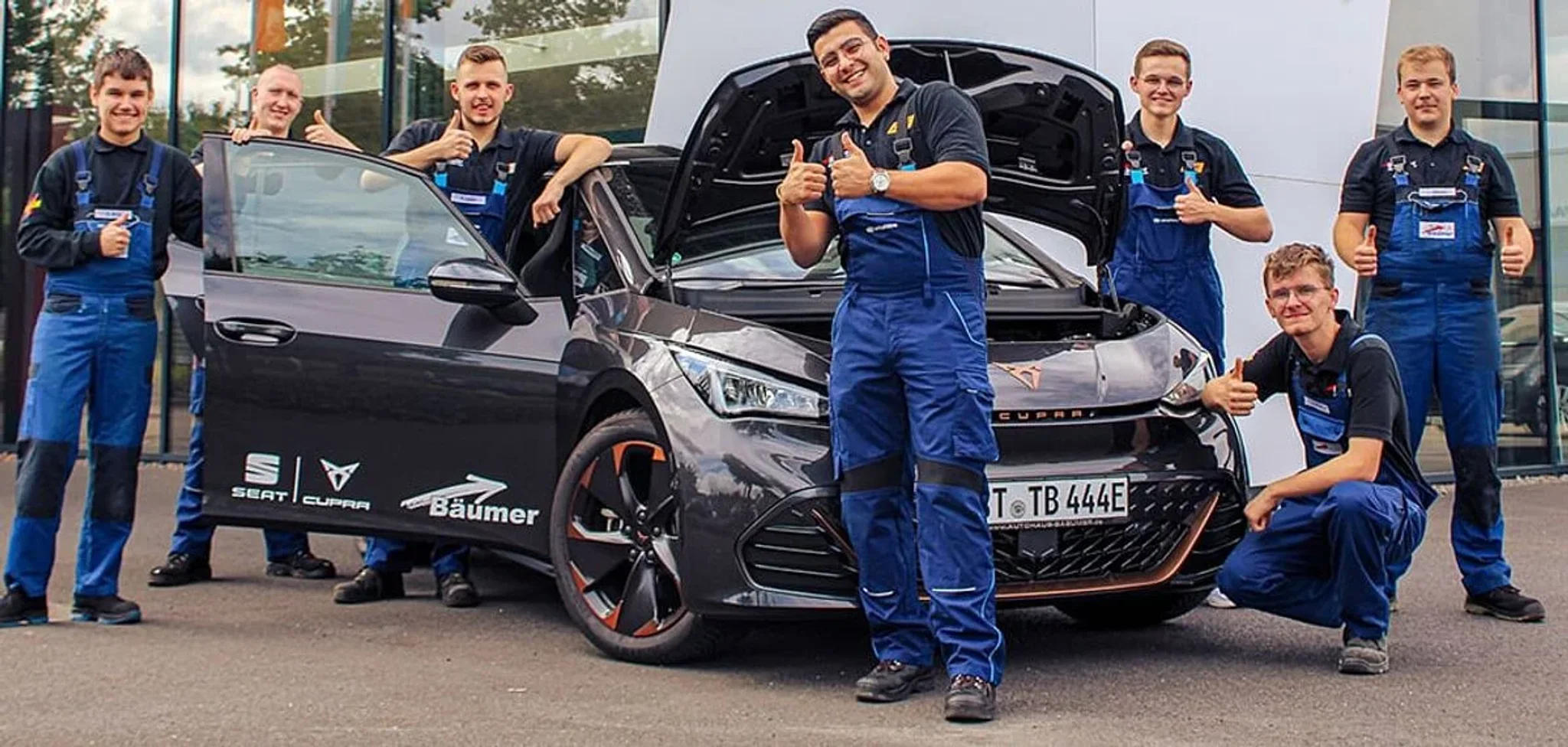 Auszubildende im Autohaus Bäumer vor einem Cupra Born