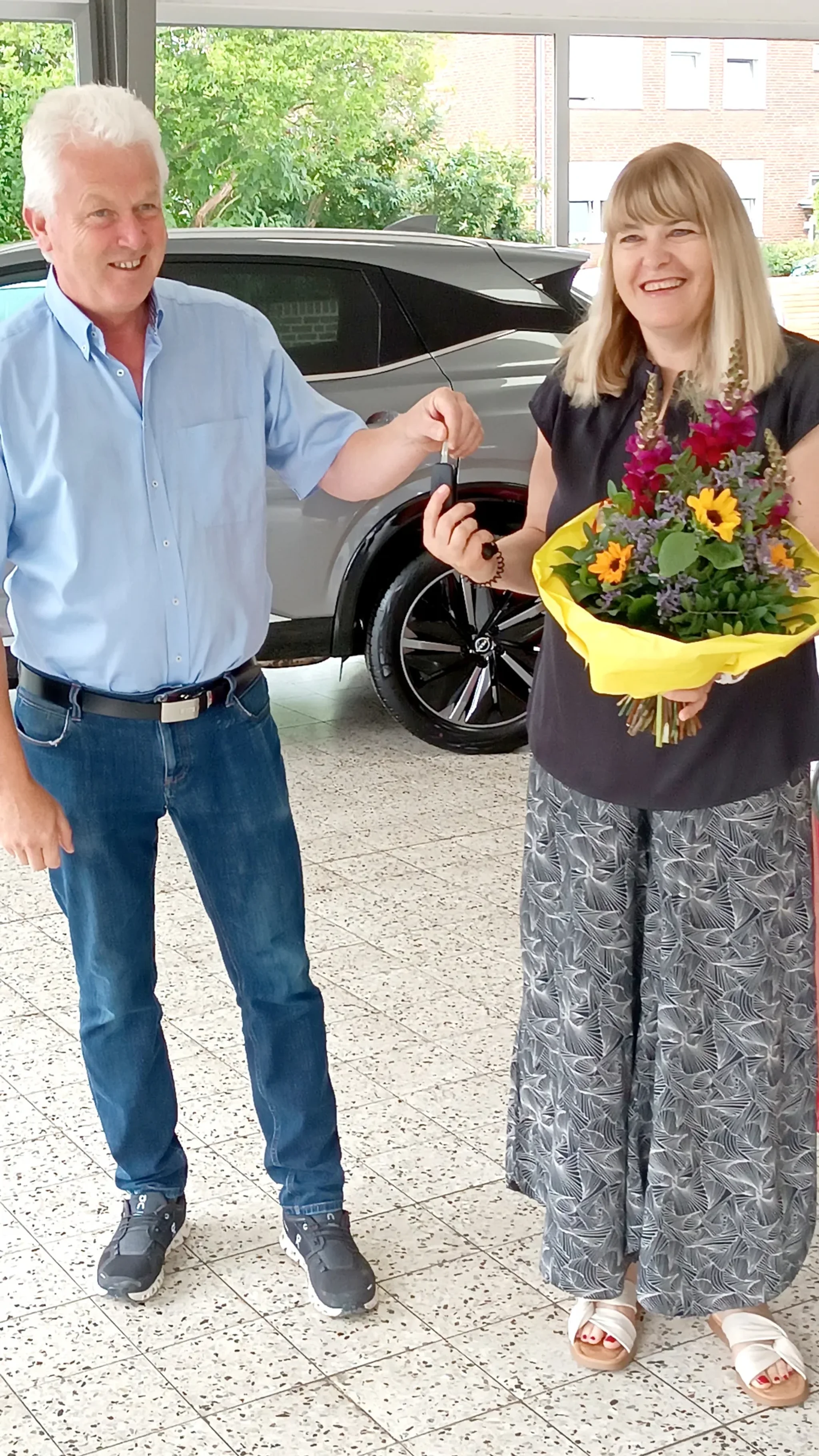 Die Gewinnerin des Gewinnspiel der Baumesse, bei der Schlüsselübergabe ihres neuen Mitsubishi Colt im Autohaus Lich