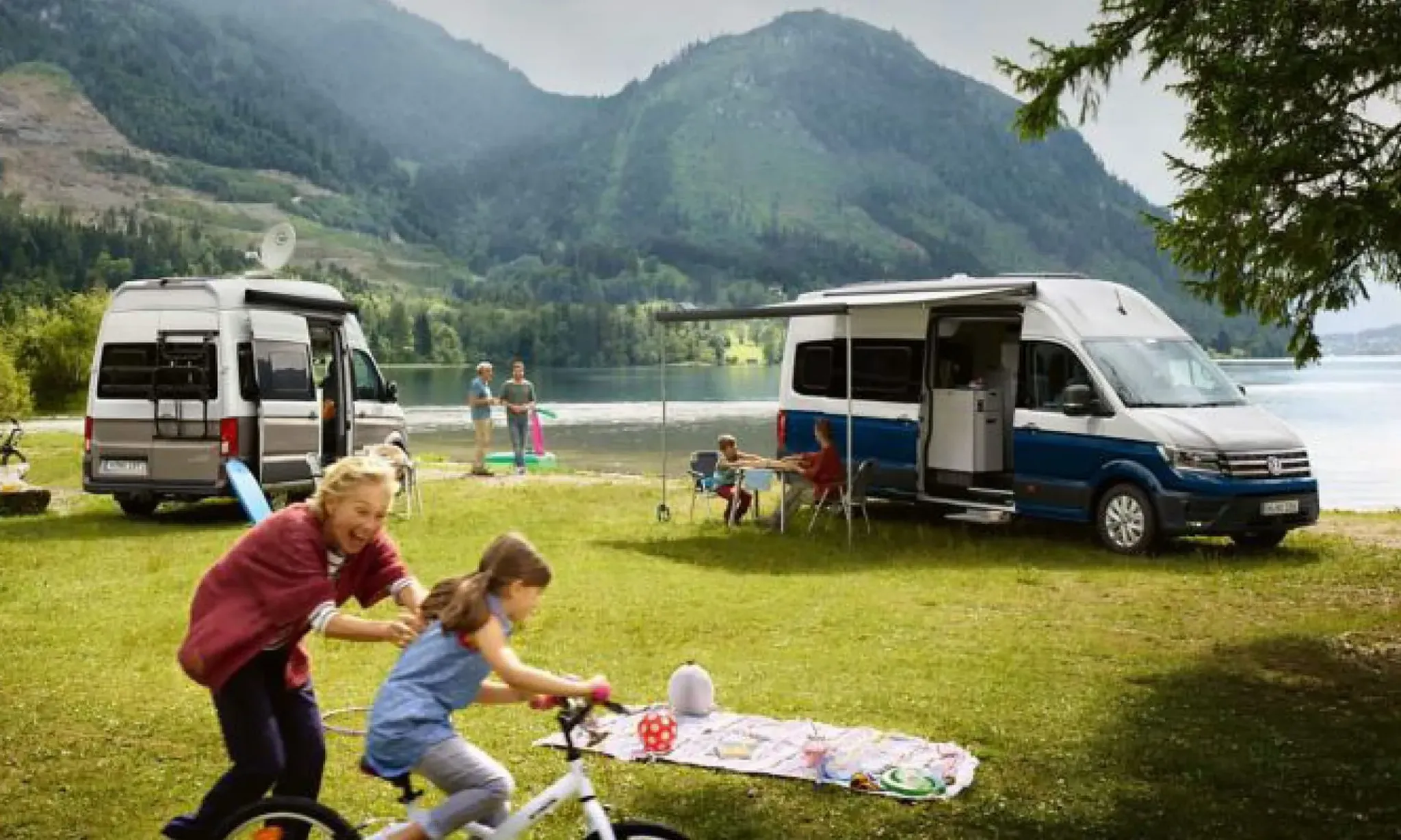 Oma mit Enkel vor einem VW Crafter am See