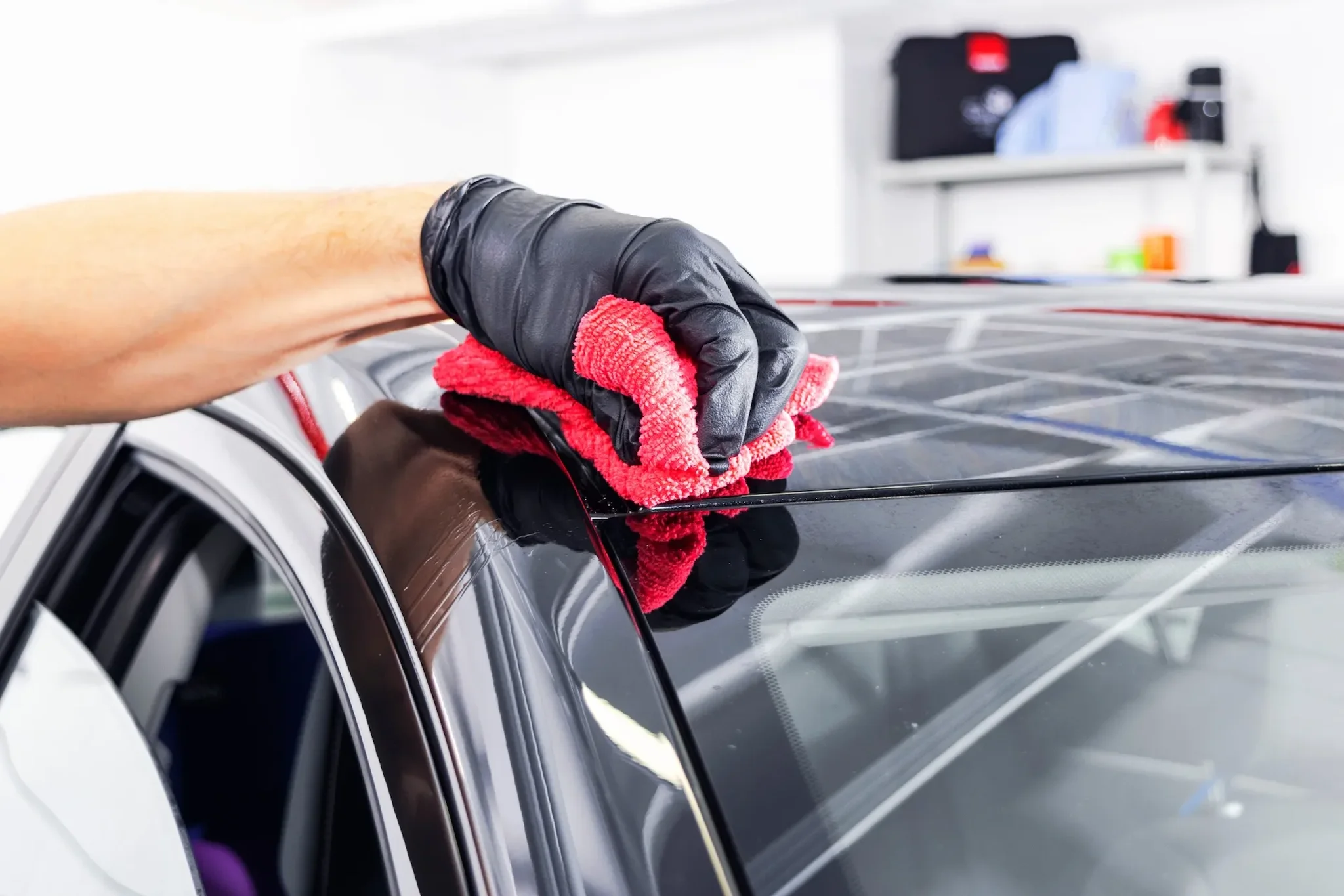 Dach eines schwarzen Fahrzeug wird poliert
