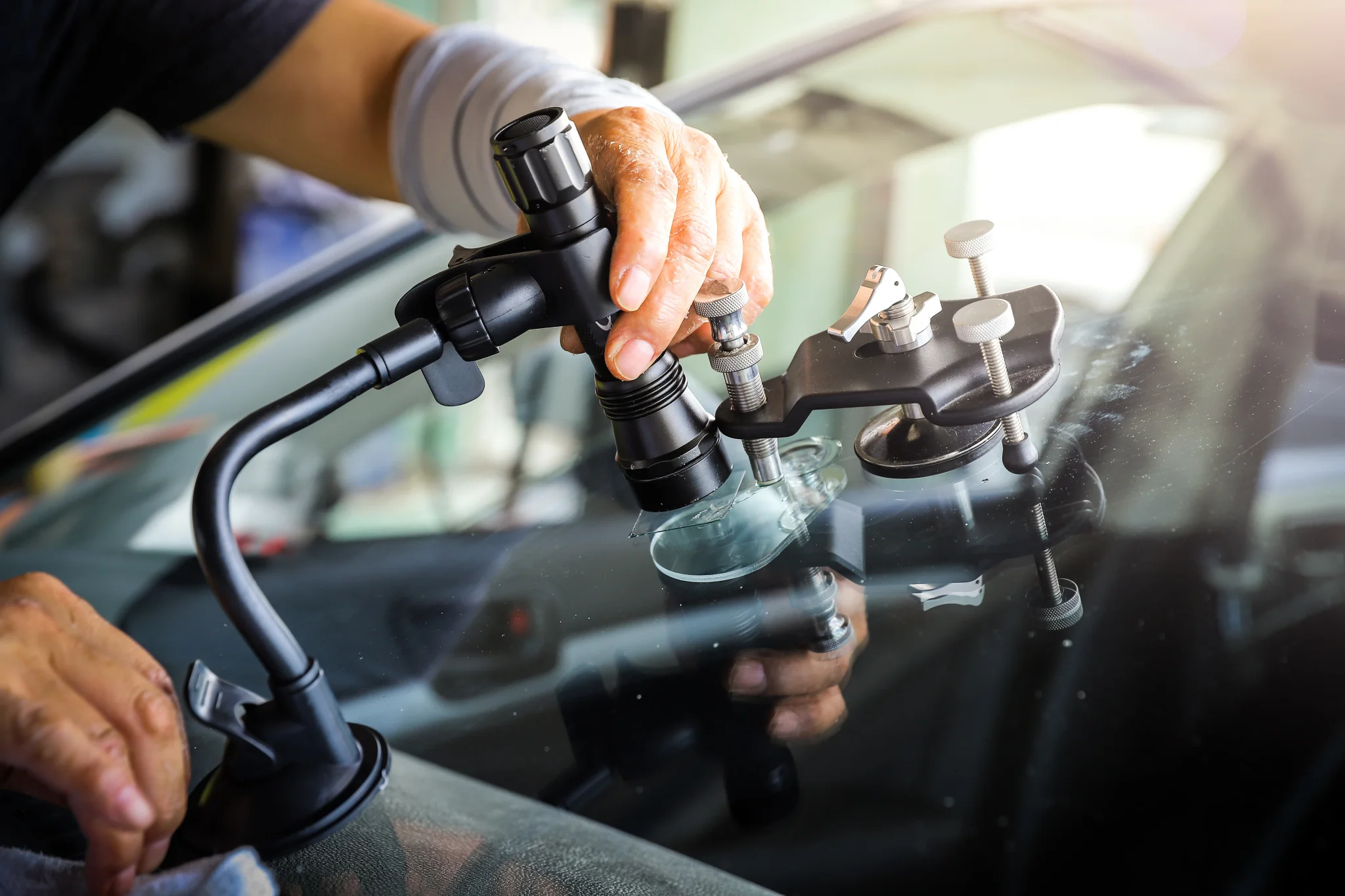 Kfz-Mechaniker beim instandsetzen eines Steinschlag auf der Frontscheibe