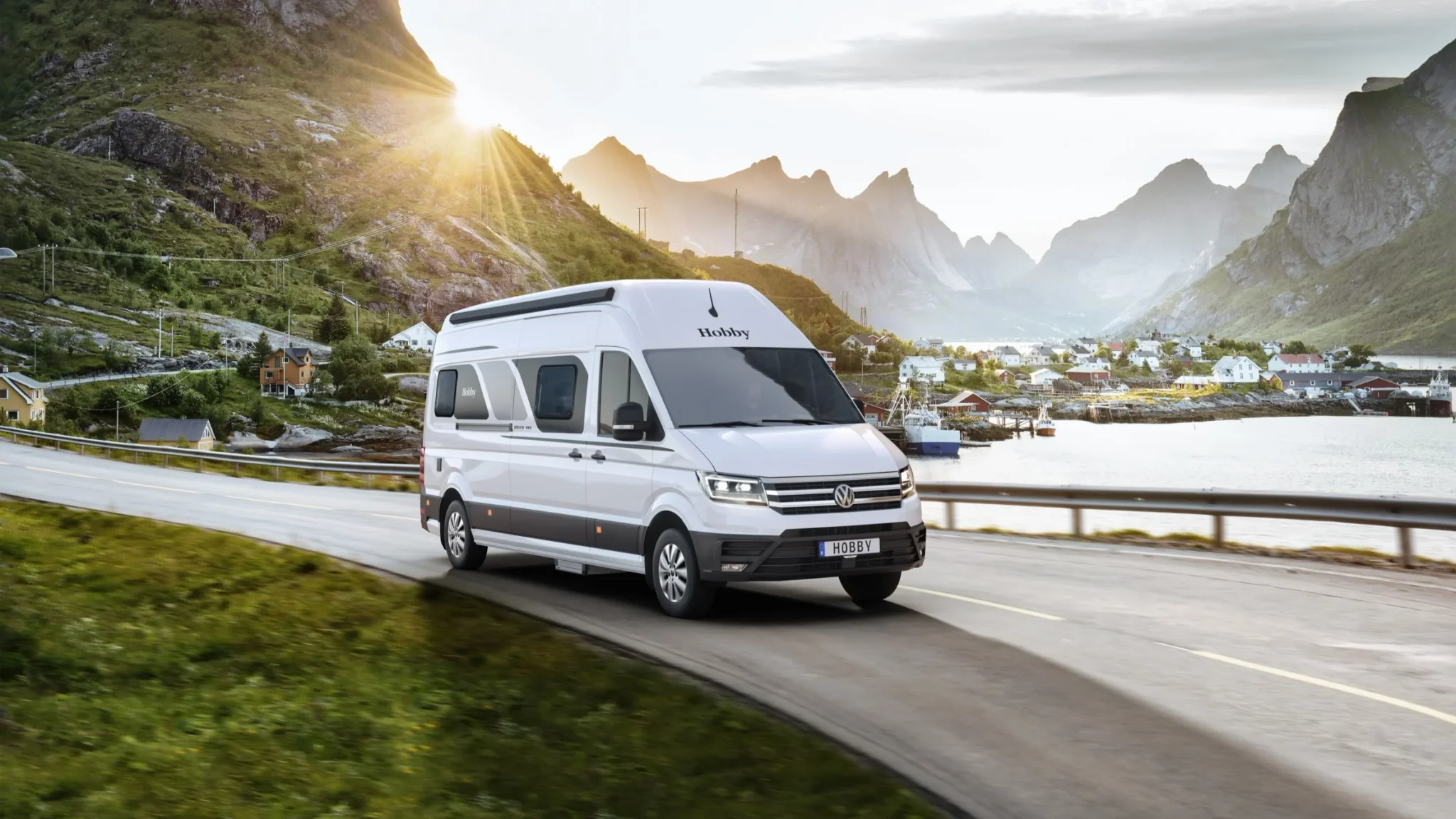 Weißer Hobby Maxia Camper Van auf einer Straße am Wasser