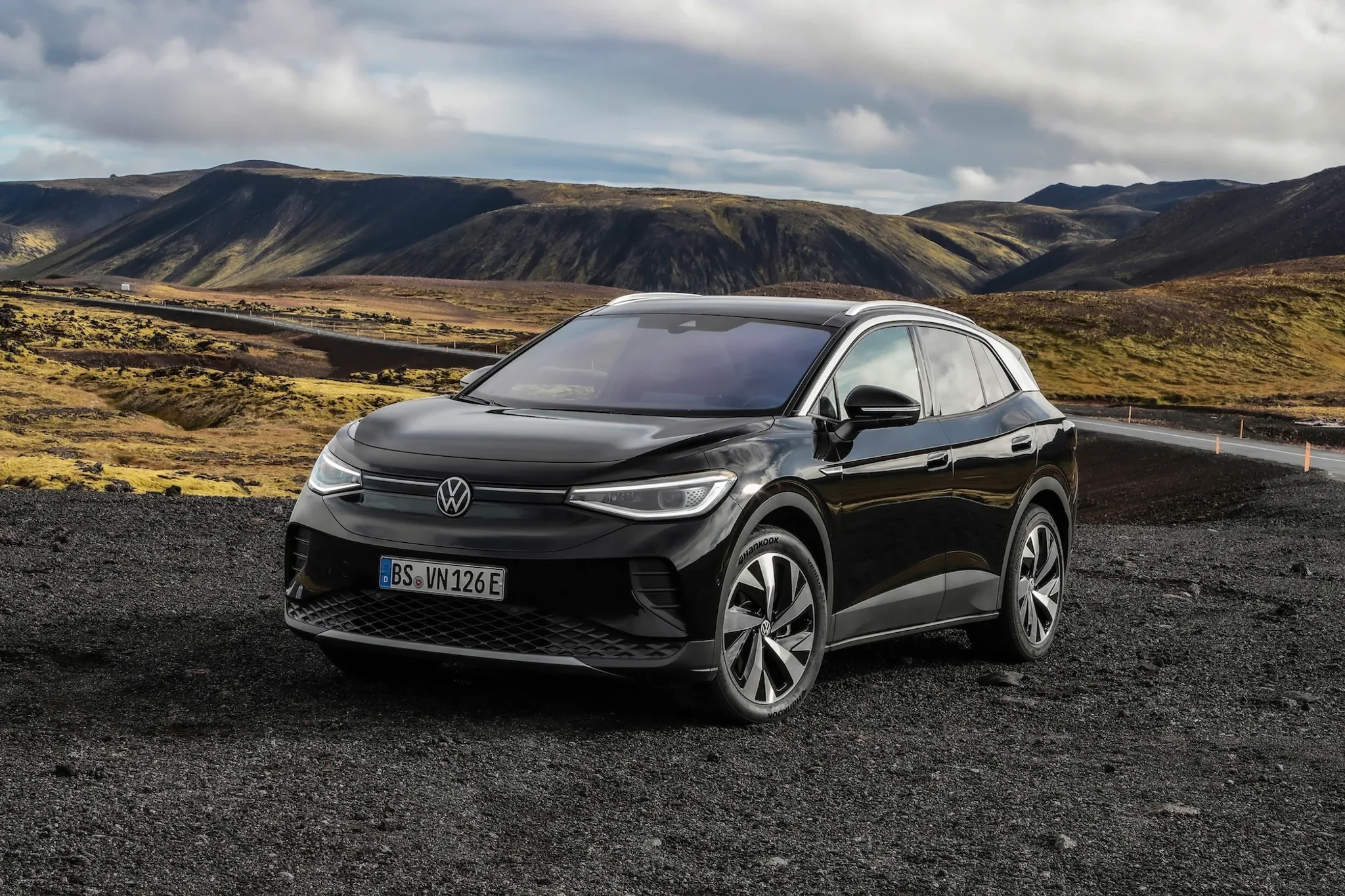 VW ID.4 in schwarz vor einer Hügelkette fotografiert.