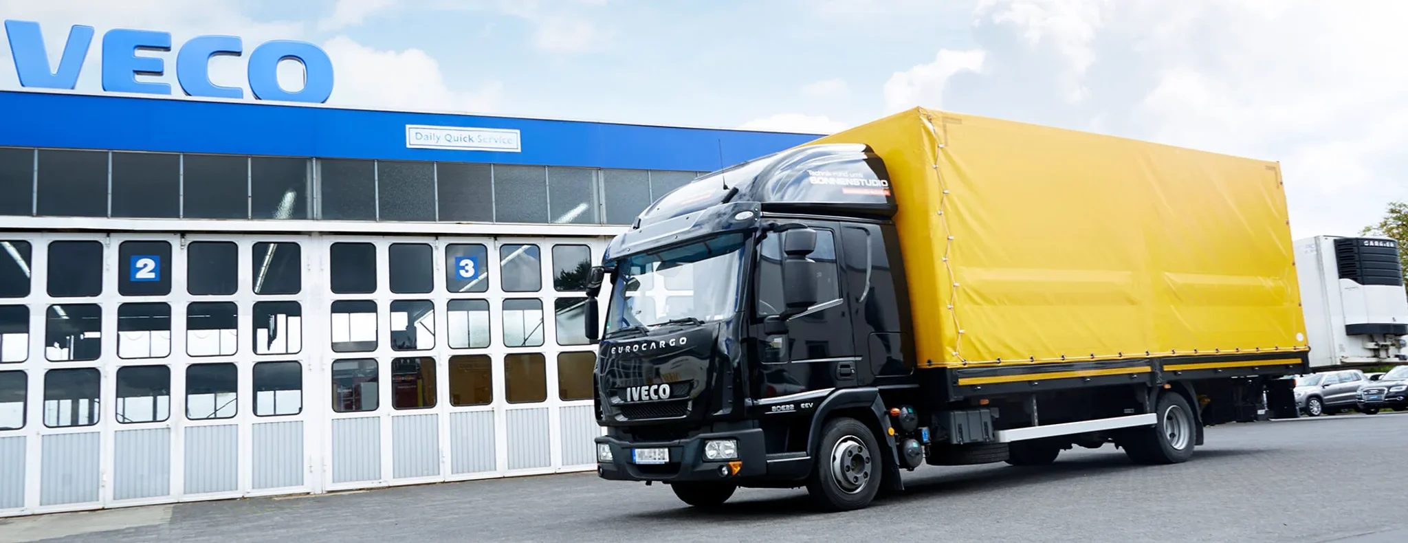 Iveco LKW in schwarz mit gelben planen Aufbau vor der Autozentrale Sturm.