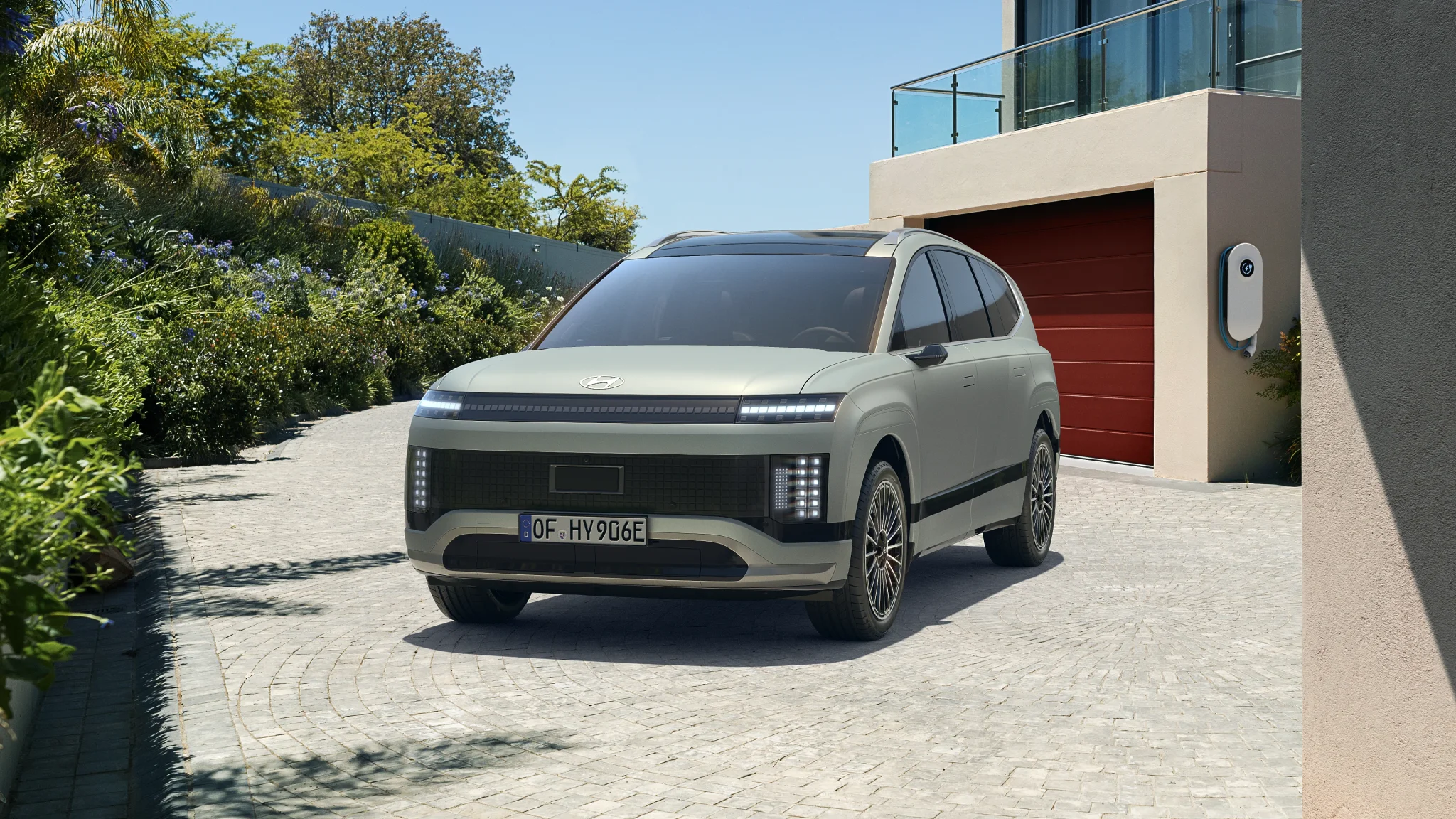 Hyundai Ioniq 9 in grau metallic von vorne links fotografiert. Parken vor einer Garage..