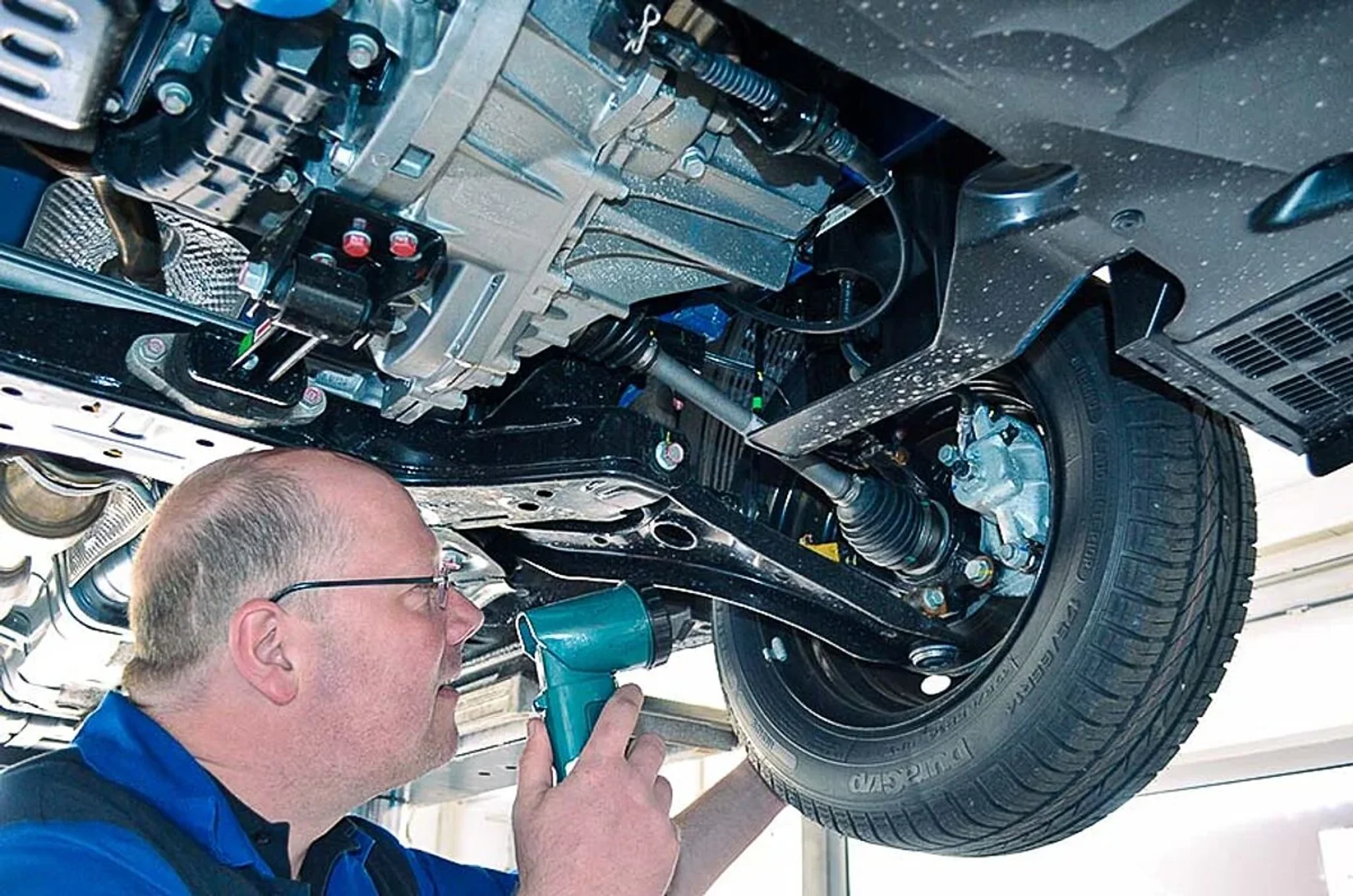 Fahrzeug auf einer Hebebühne und Kfz Mechaniker