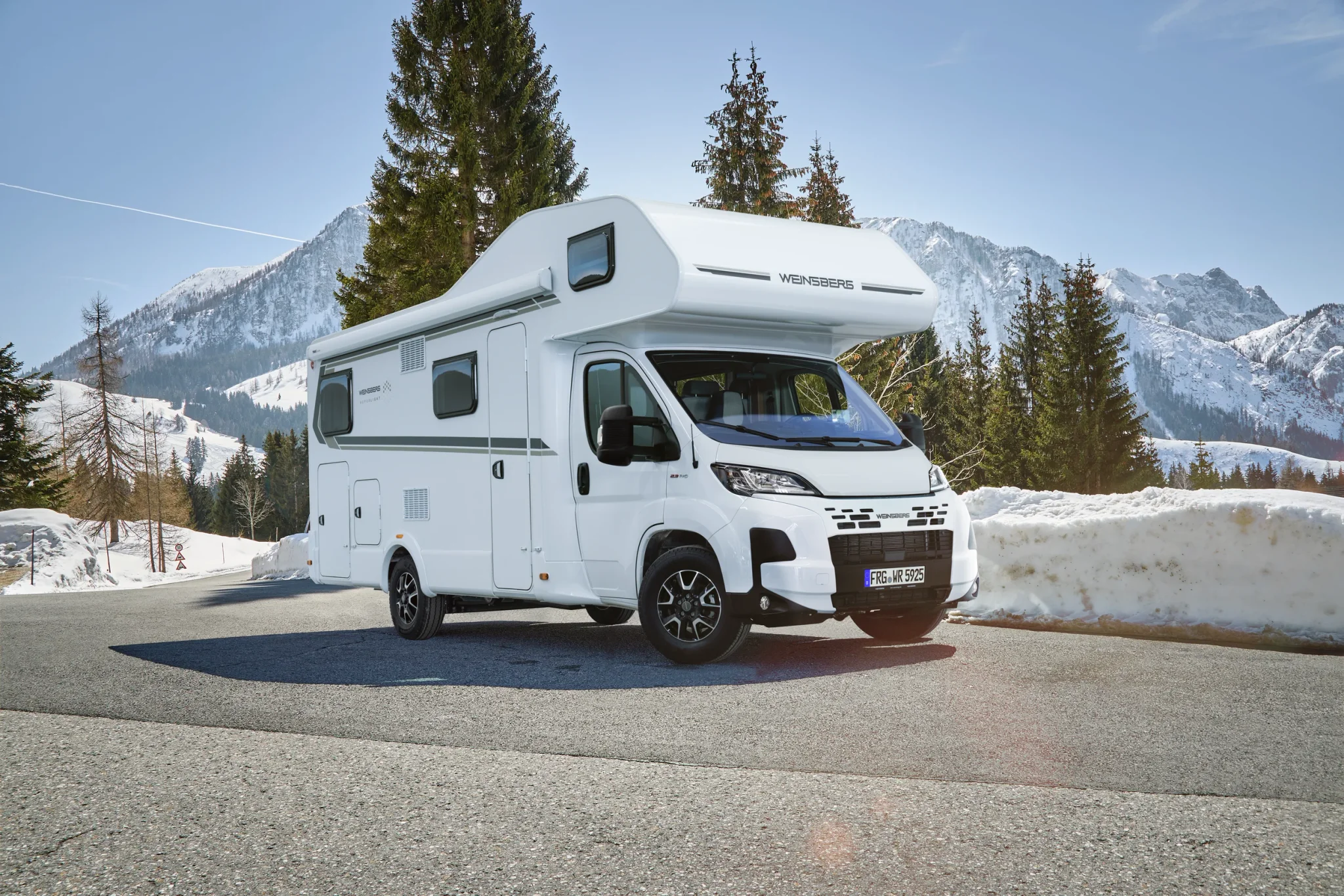 Weinsberg Alkoven Wohnmobil auf einer Straße mit Schnee im Hintergrund