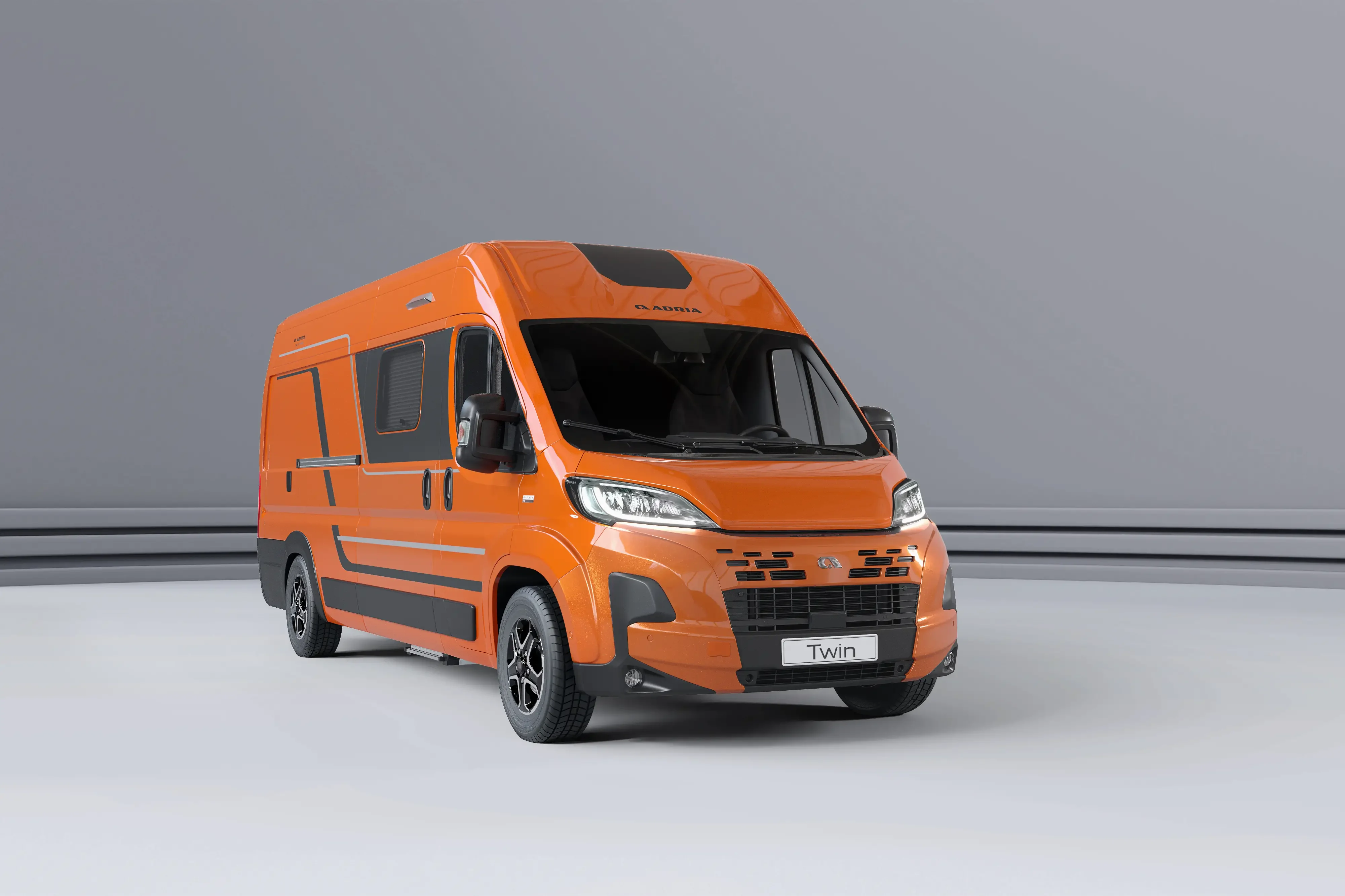 Oranger Adria Twin Camper Van (Kastenwagen) in der Seitenansicht vor neutralem Hintergrund.