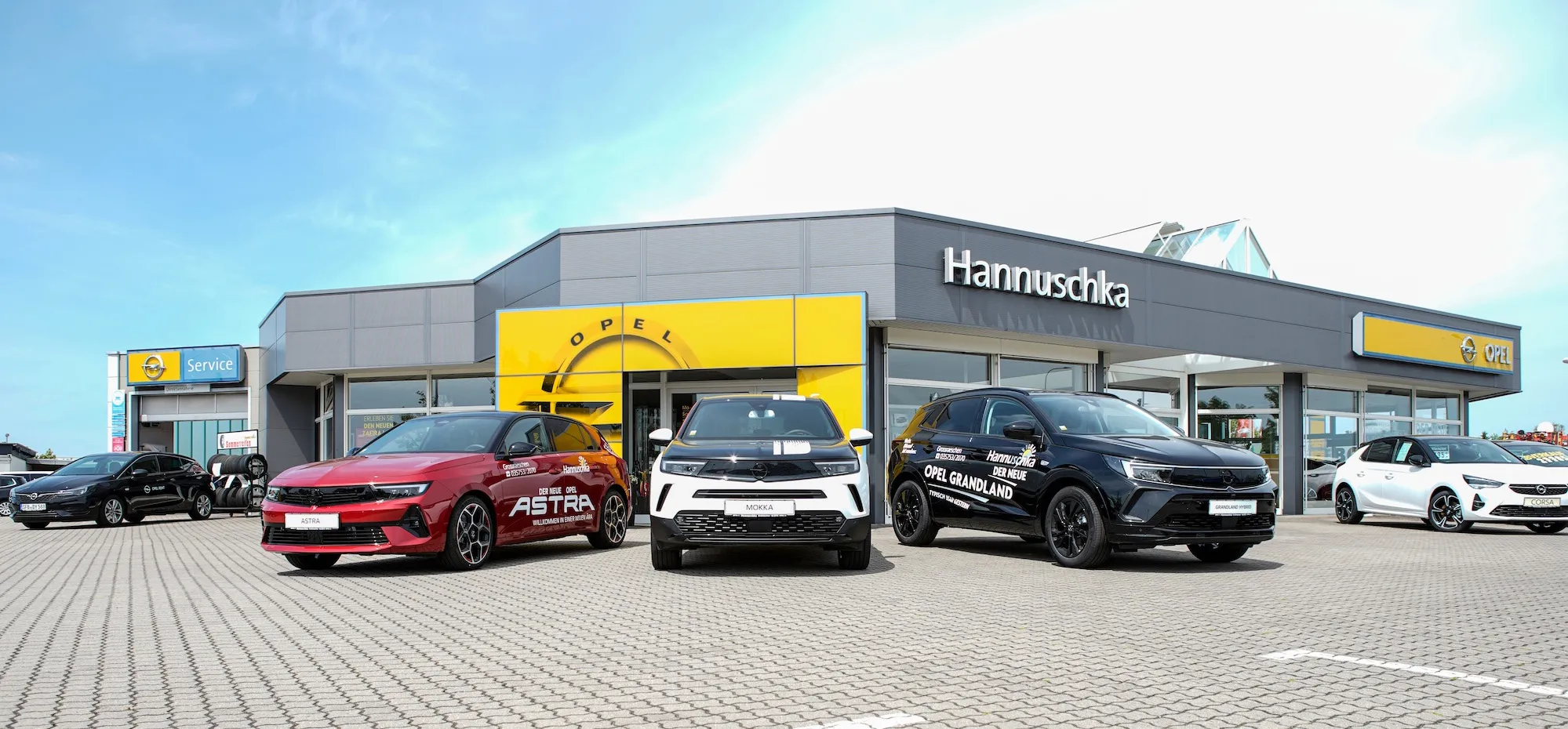 Autohaus Hannuschka von vorne Richtung Eingang Perspektive fotografiert mit Hannuschka Schriftzug am Dach und Fahrzeugen vor dem Autohaus