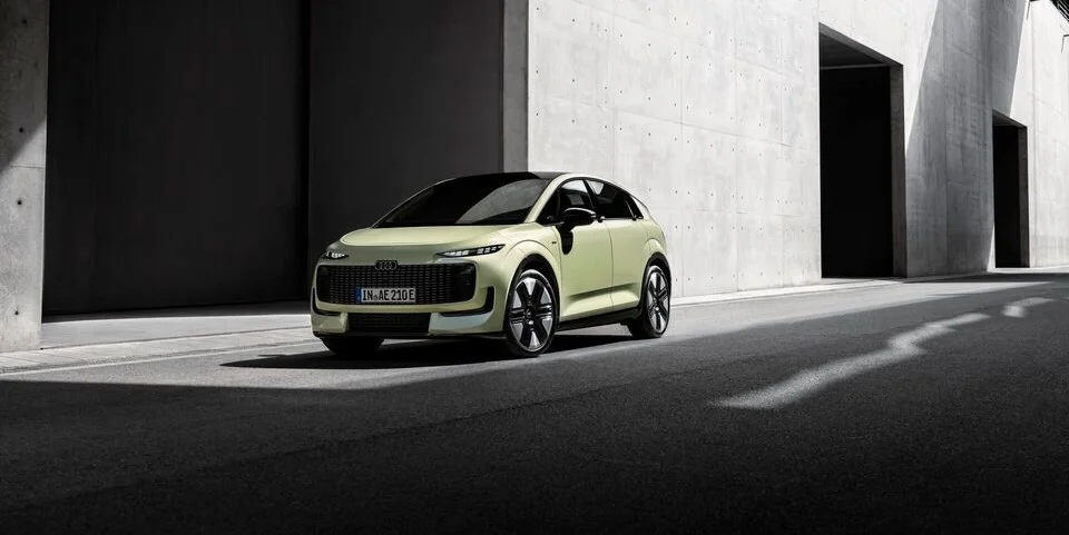 Audi A2 e-tron in Pistaziengrün Metallic vor einem Industriegebäude.jpg