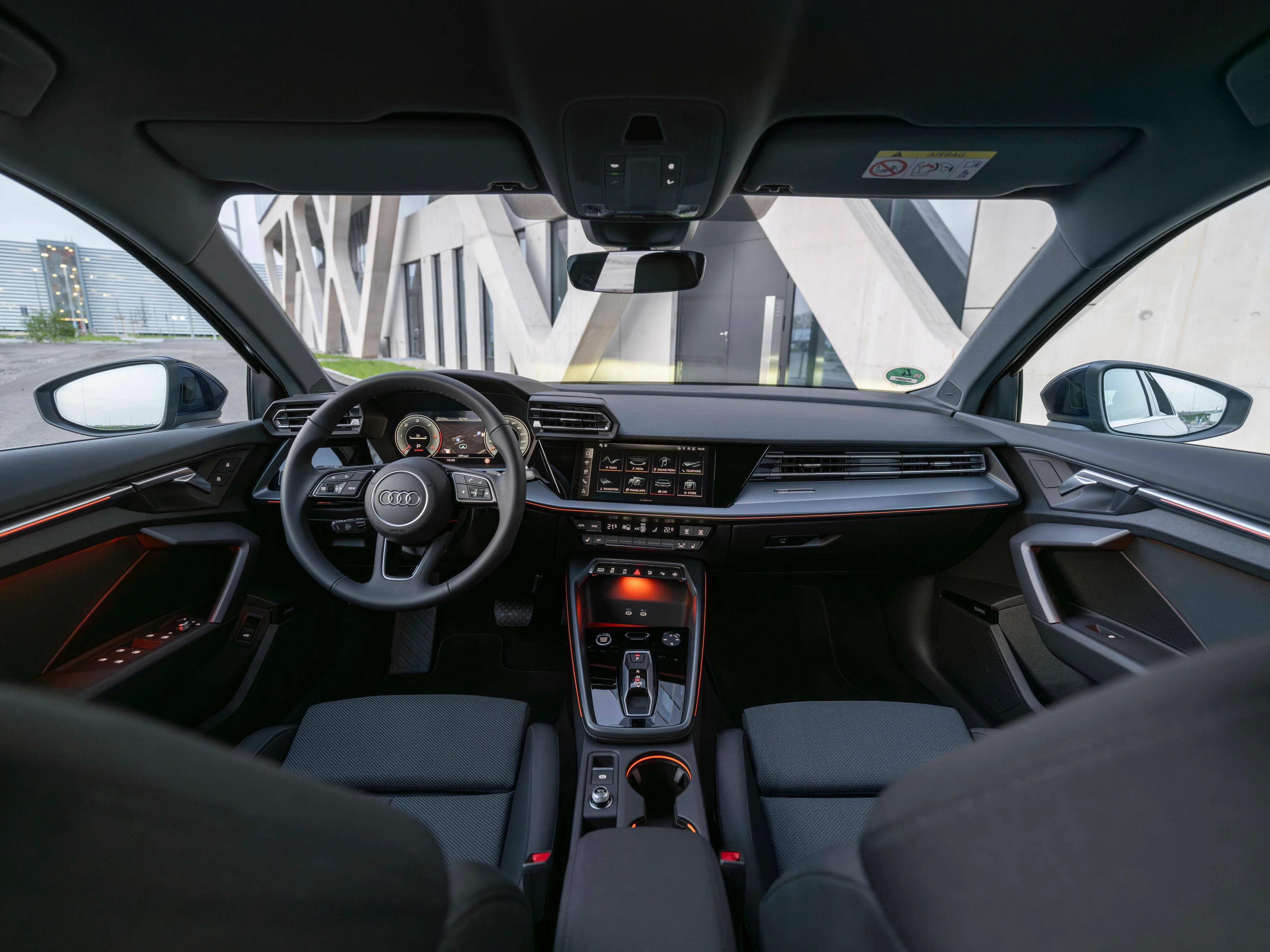 Interieur des Audi A3 Sportback in schwarz mit orangefarbenen Lichtelementen.