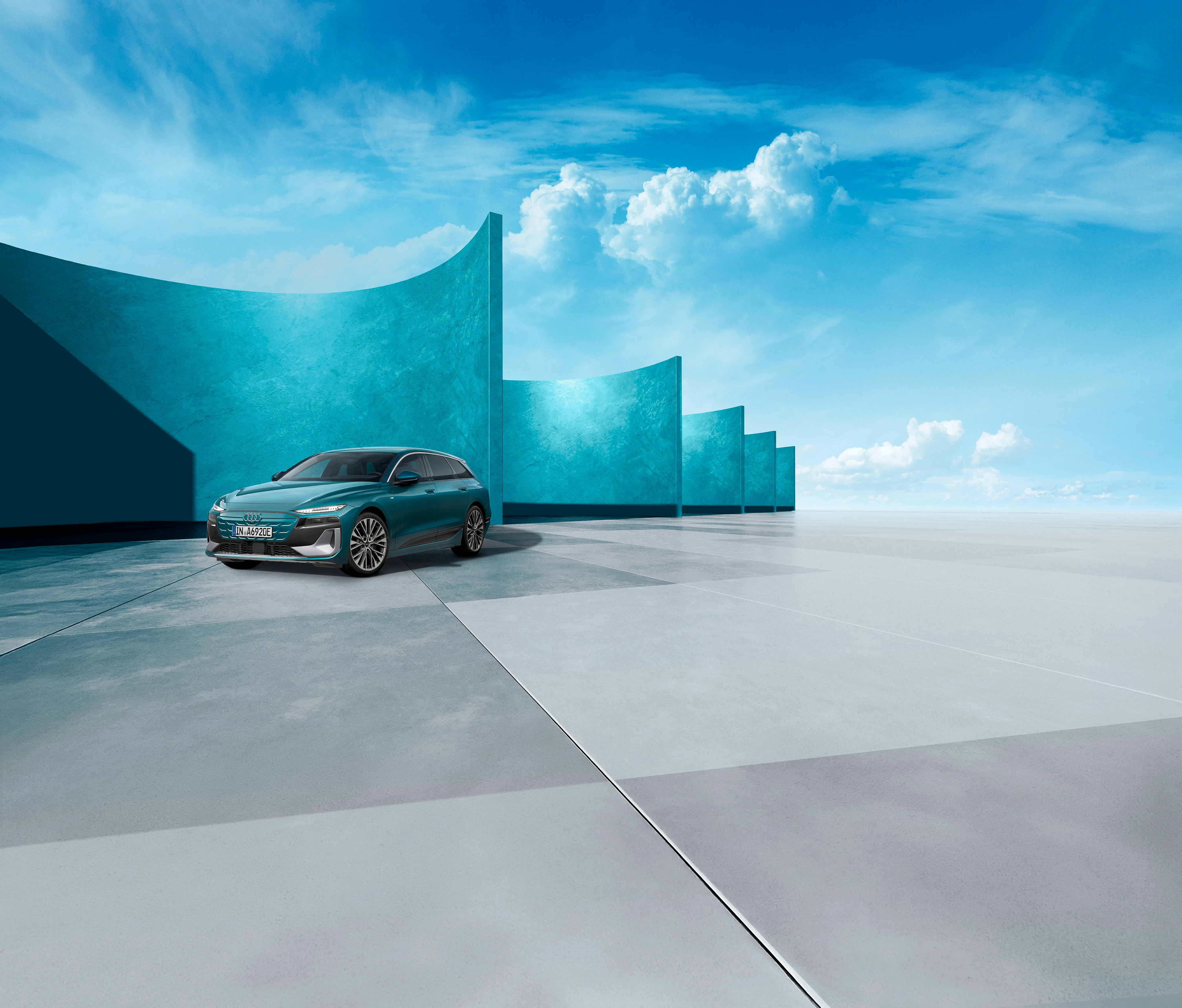 Grünblauer Audi A6 e-tron vor blau-grauem modernen Hintergrund
