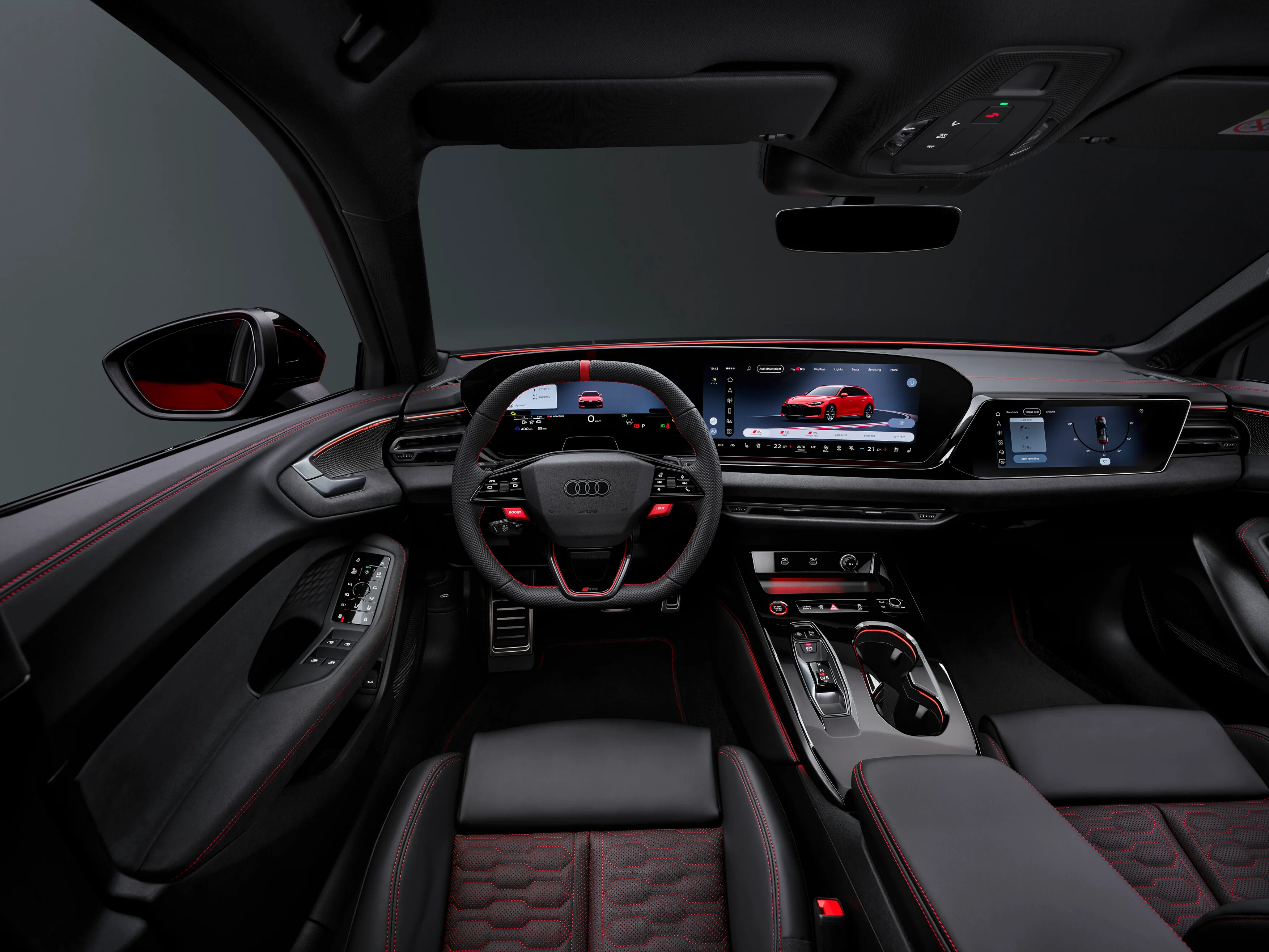 Innenraum aus Sicht des Fahrers des Audi RS 5 Avant in schwarz mit roten Details.