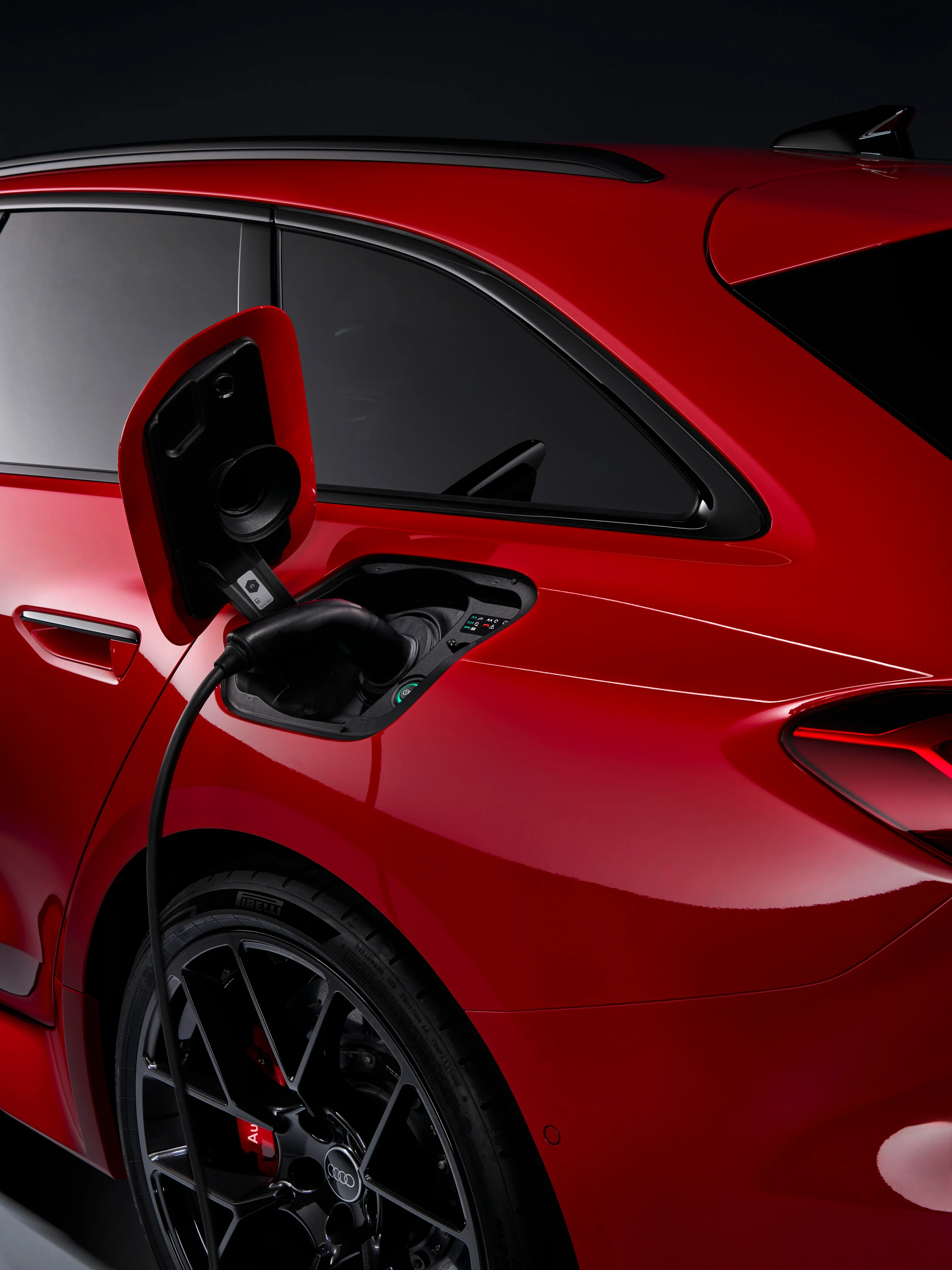 Ausschnitt des Audi RS 5 Avant in rot mit Blick auf den geöffneten Ladeanschluss.