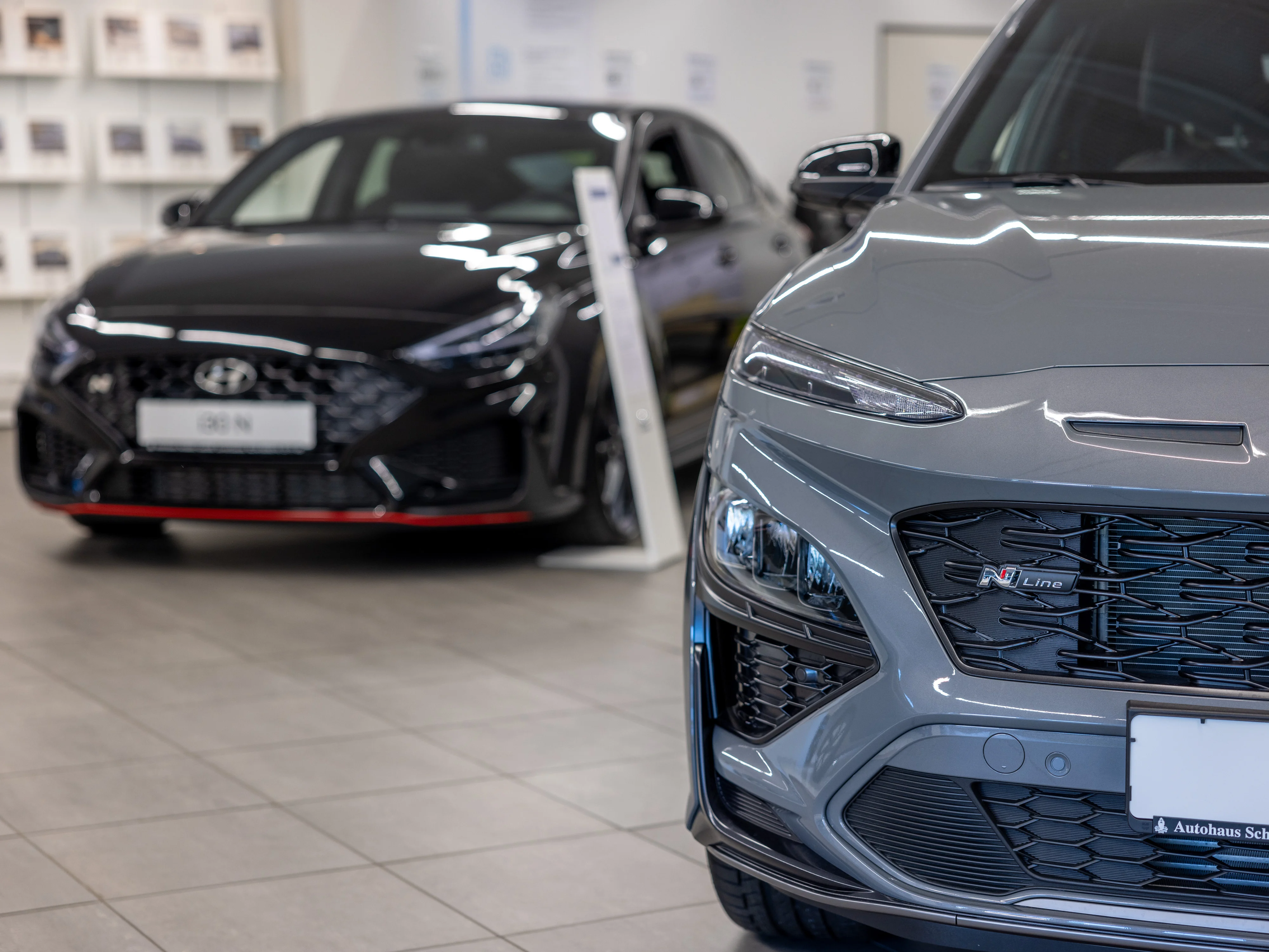 Zwei Fahrzeuge der Marke Hyundai Schreck versetzt hintereinander stehend in grau und schwarz.