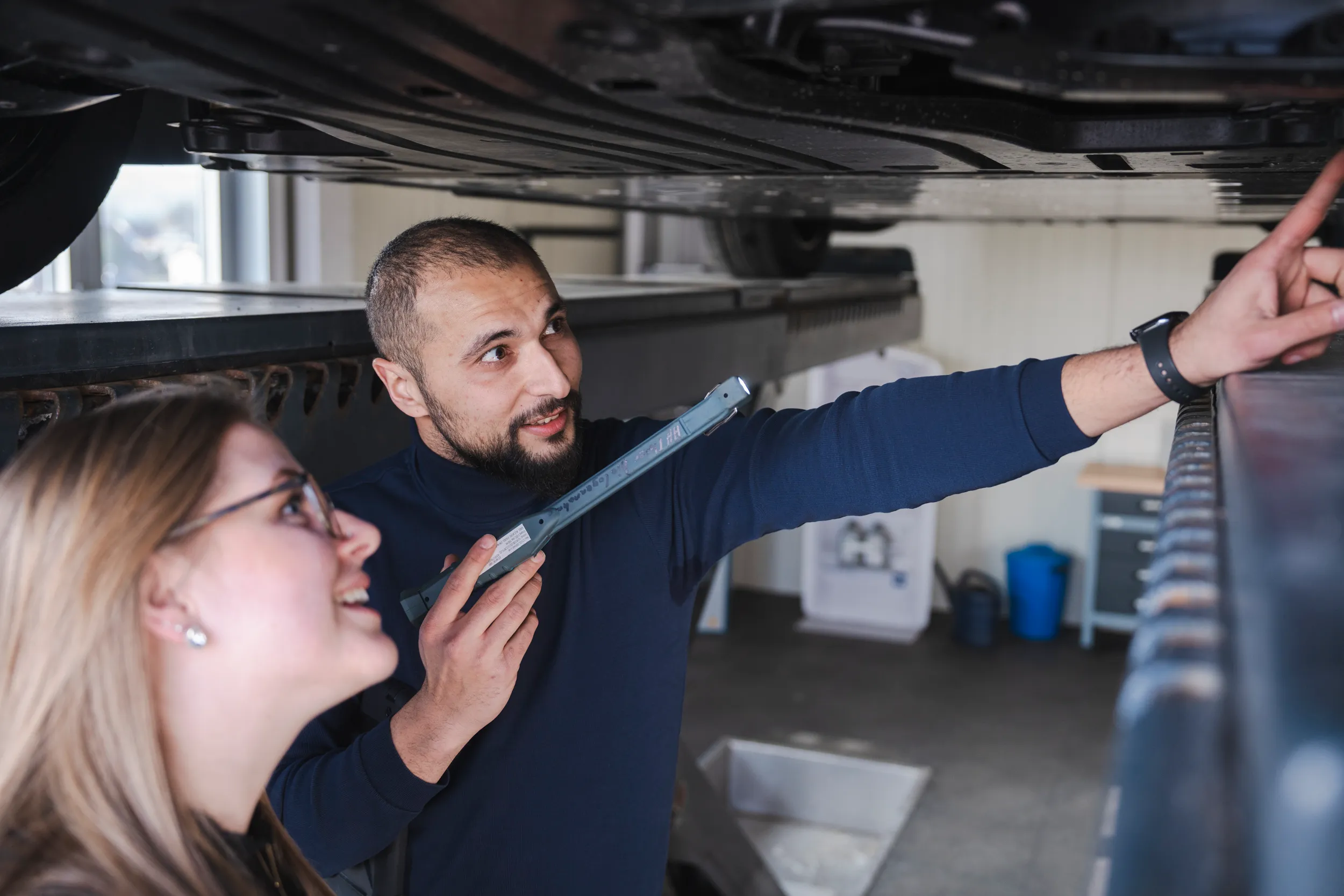 Mitarbeiter des Autohaus Moser erklärt einer Kundin den Fahrzeugzustand