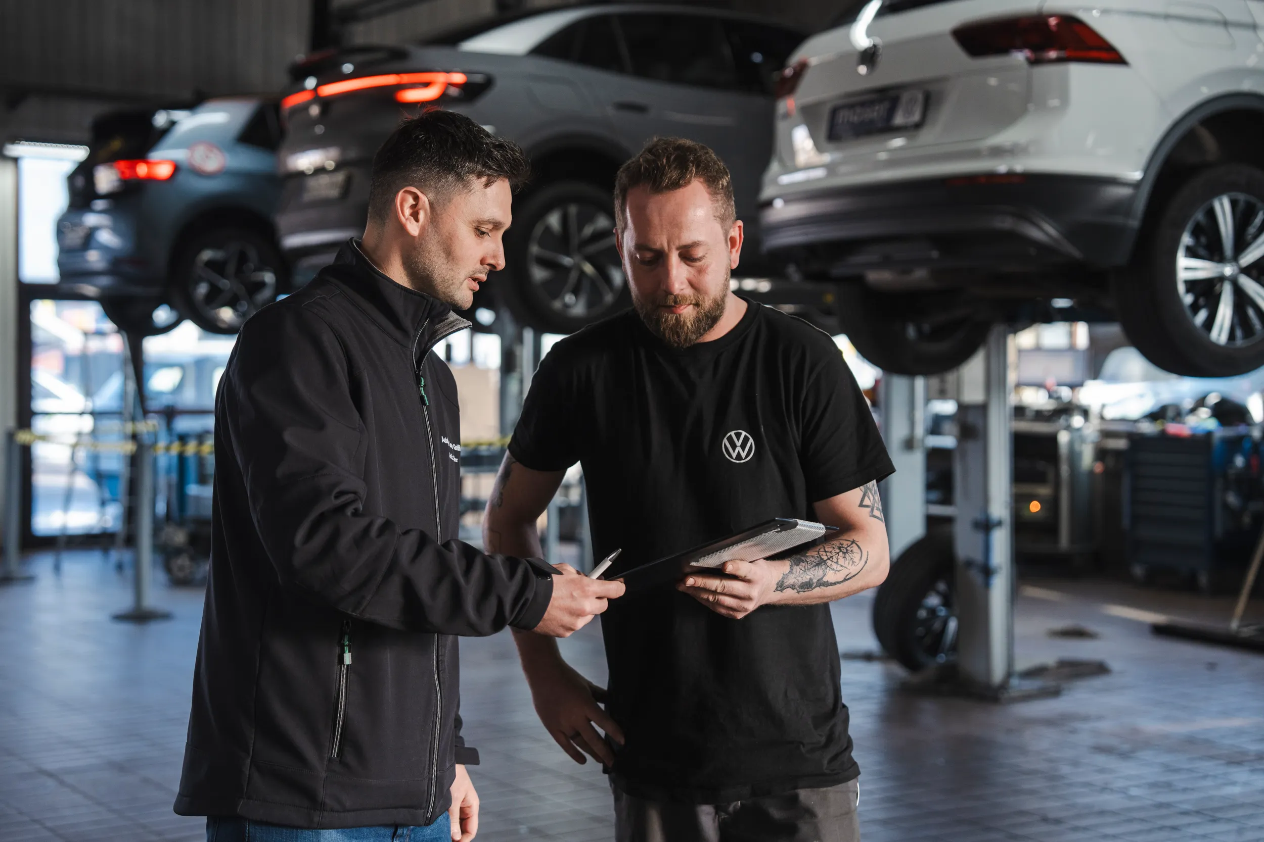 Zwei Service Mitarbeiter des Autohaus Moser in der Werkstatt beim Gedankenaustausch