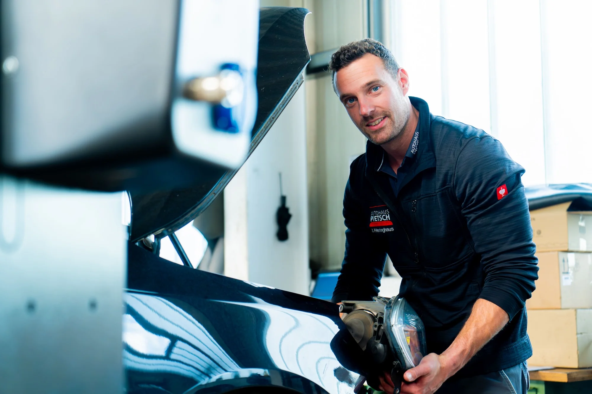 Mitarbeiter ins Autohaus Pietsch beim Austausch eines Scheinwerfers