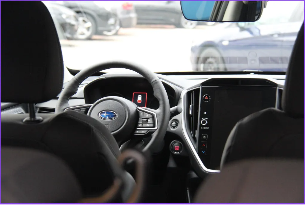Blick von hinten auf Lenkrad und zentrales Display im Innenraum eines Subaru.