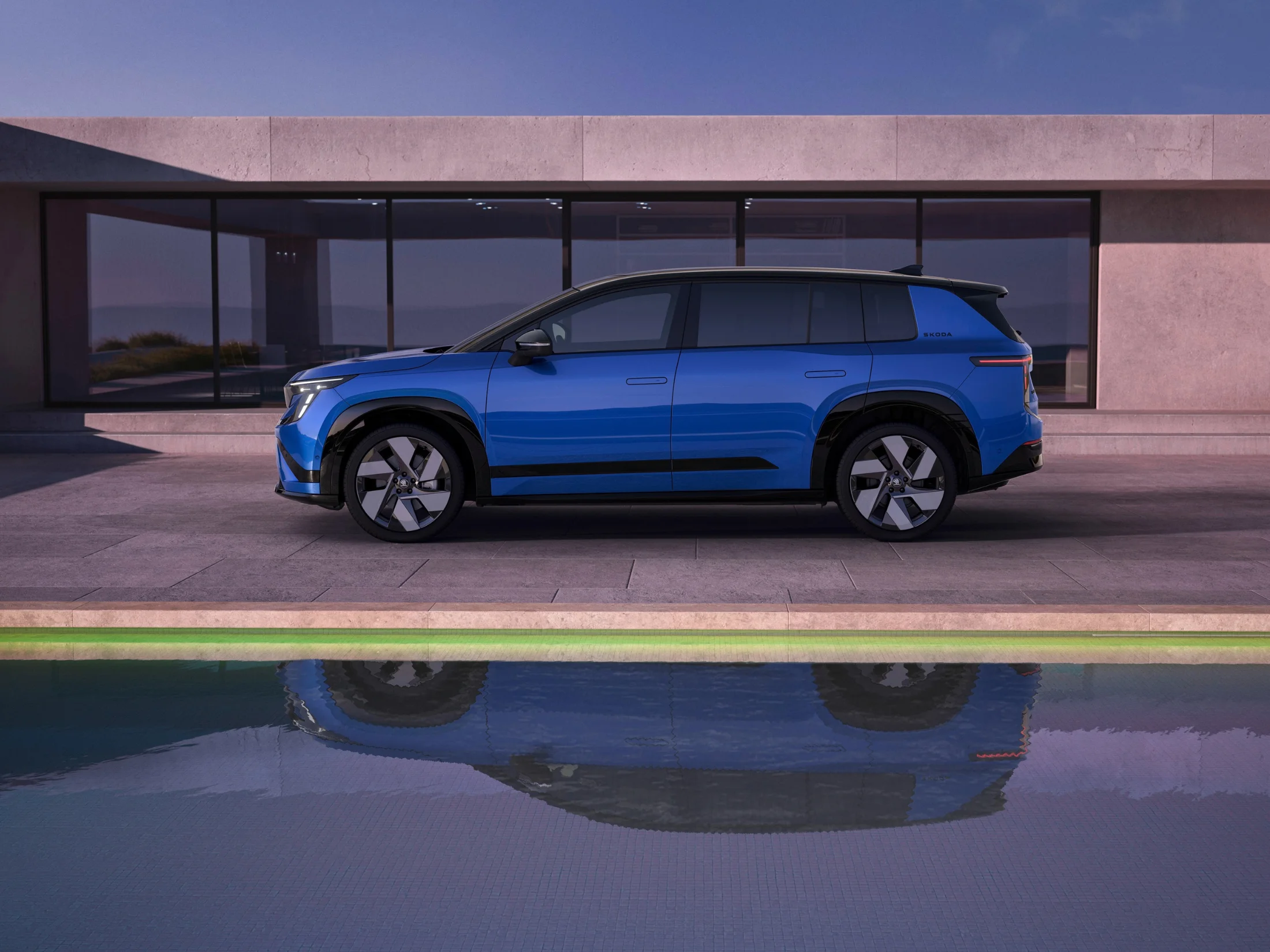 Blauer Peaq in Seitenansicht spiegelt sich im Pool vor modernem Haus.png