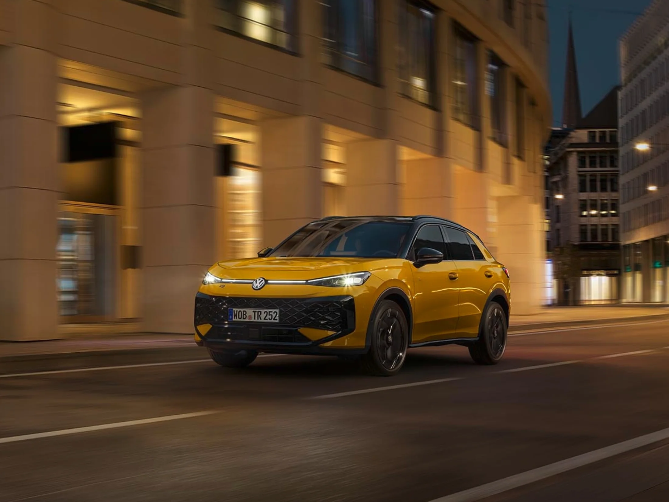 Fahrender gelber T-Roc in der Stadt bei Nacht.png
