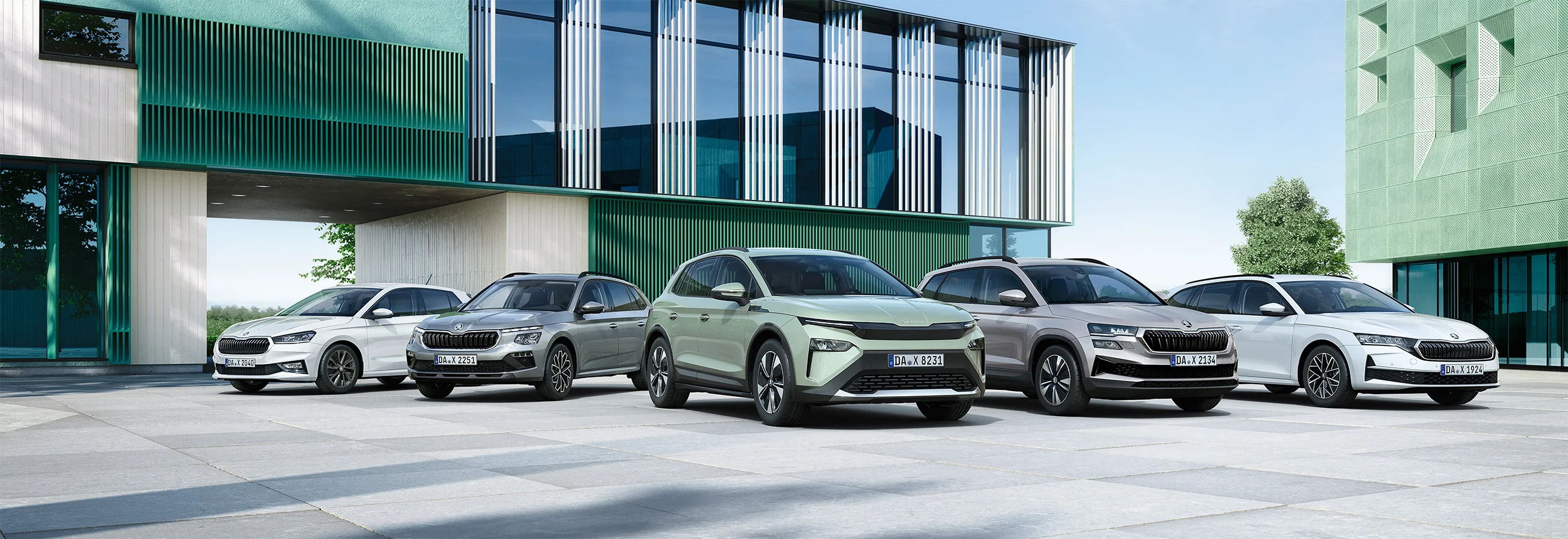 Verschiedene Skoda Modelle vor modernem Gewerbepark