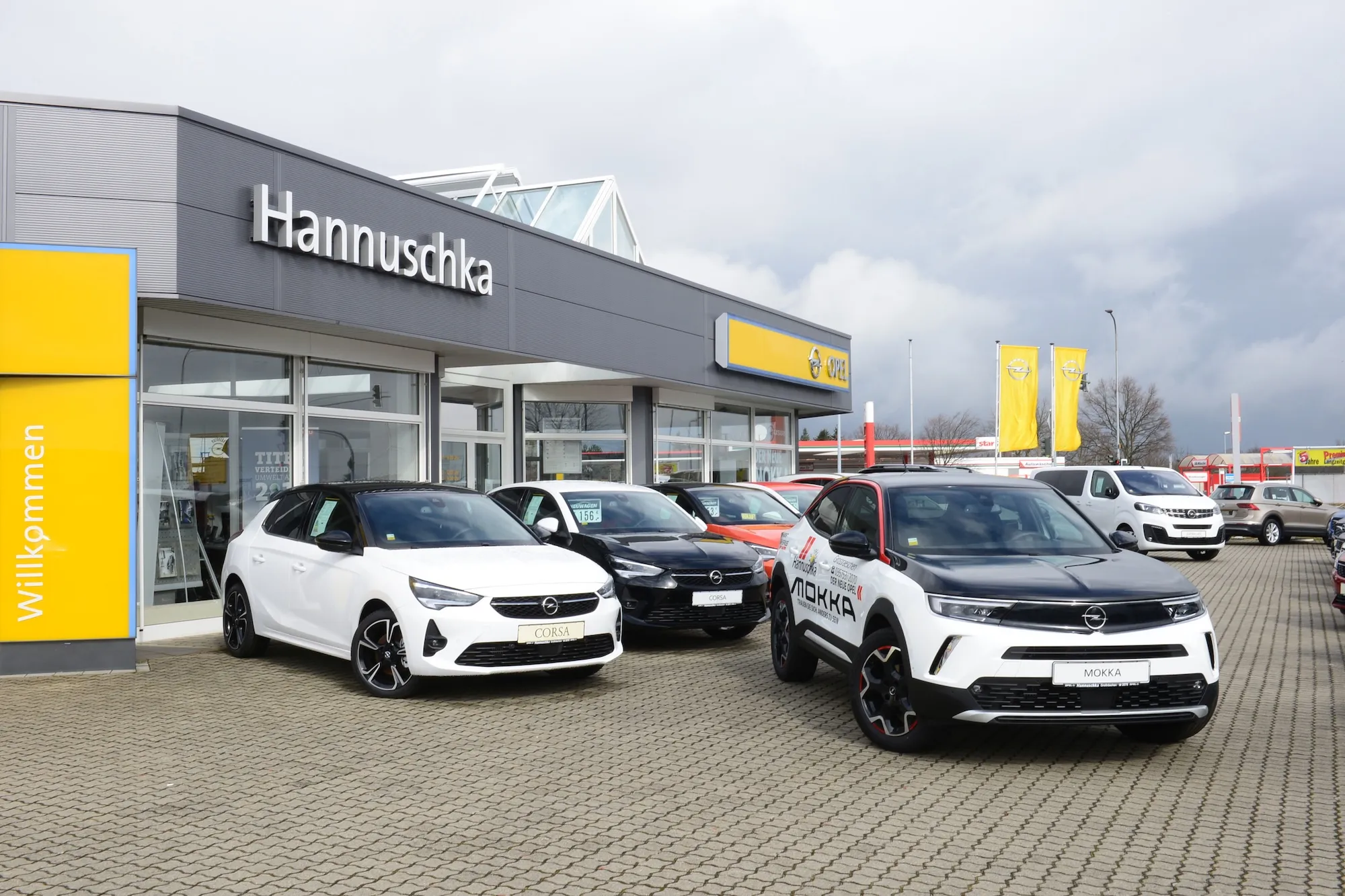 Autohaus Hannuschka im Eingangsbereich fotografiert mit einem Opel Mokka in weiß schwarz und einem Opel Corsa als dominierendes Bildelement