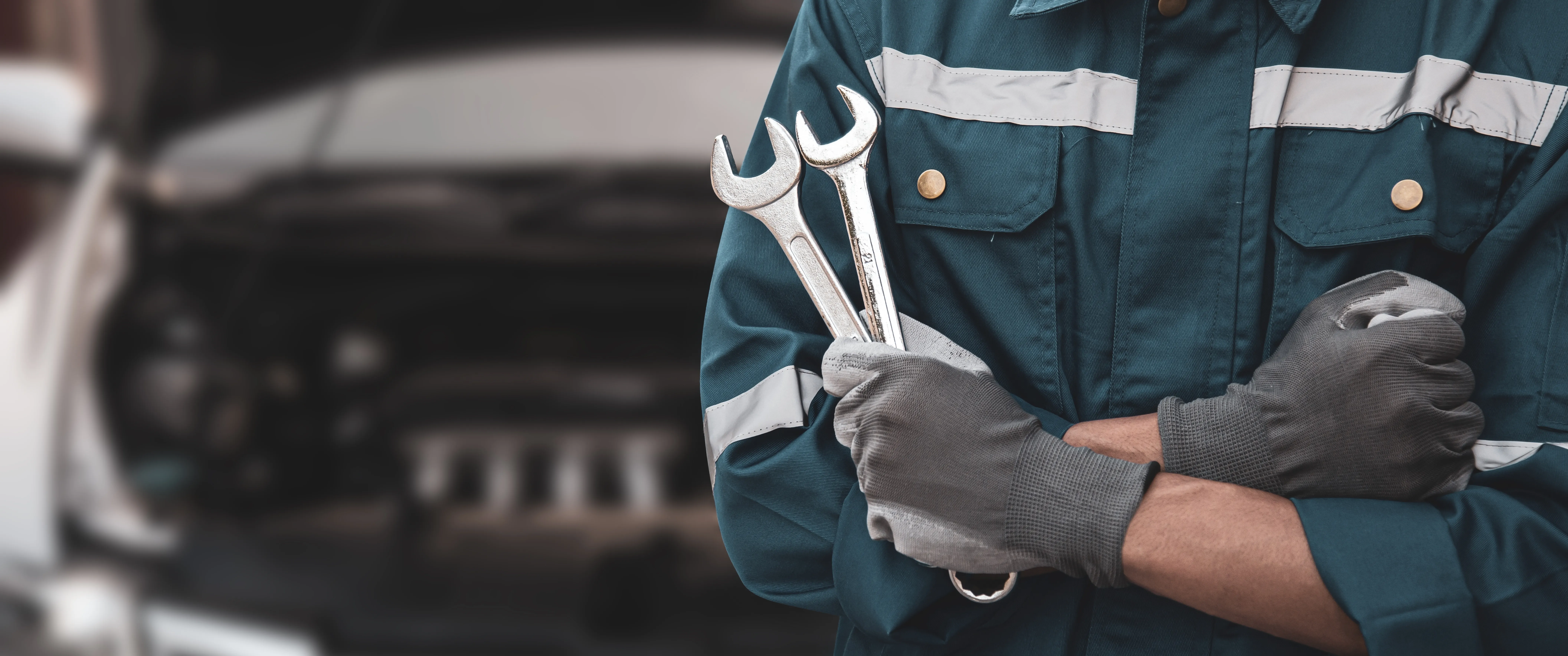Mechaniker mit zwei Schraubenschlüsseln in der Hand