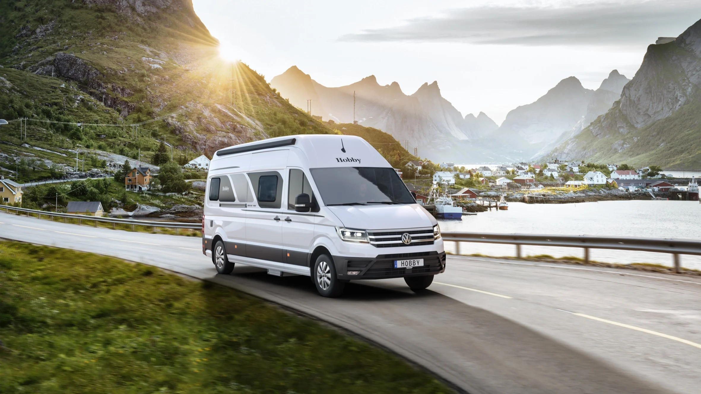 Weißer Hobby Maxia Camper Van auf einer Straße am Wasser