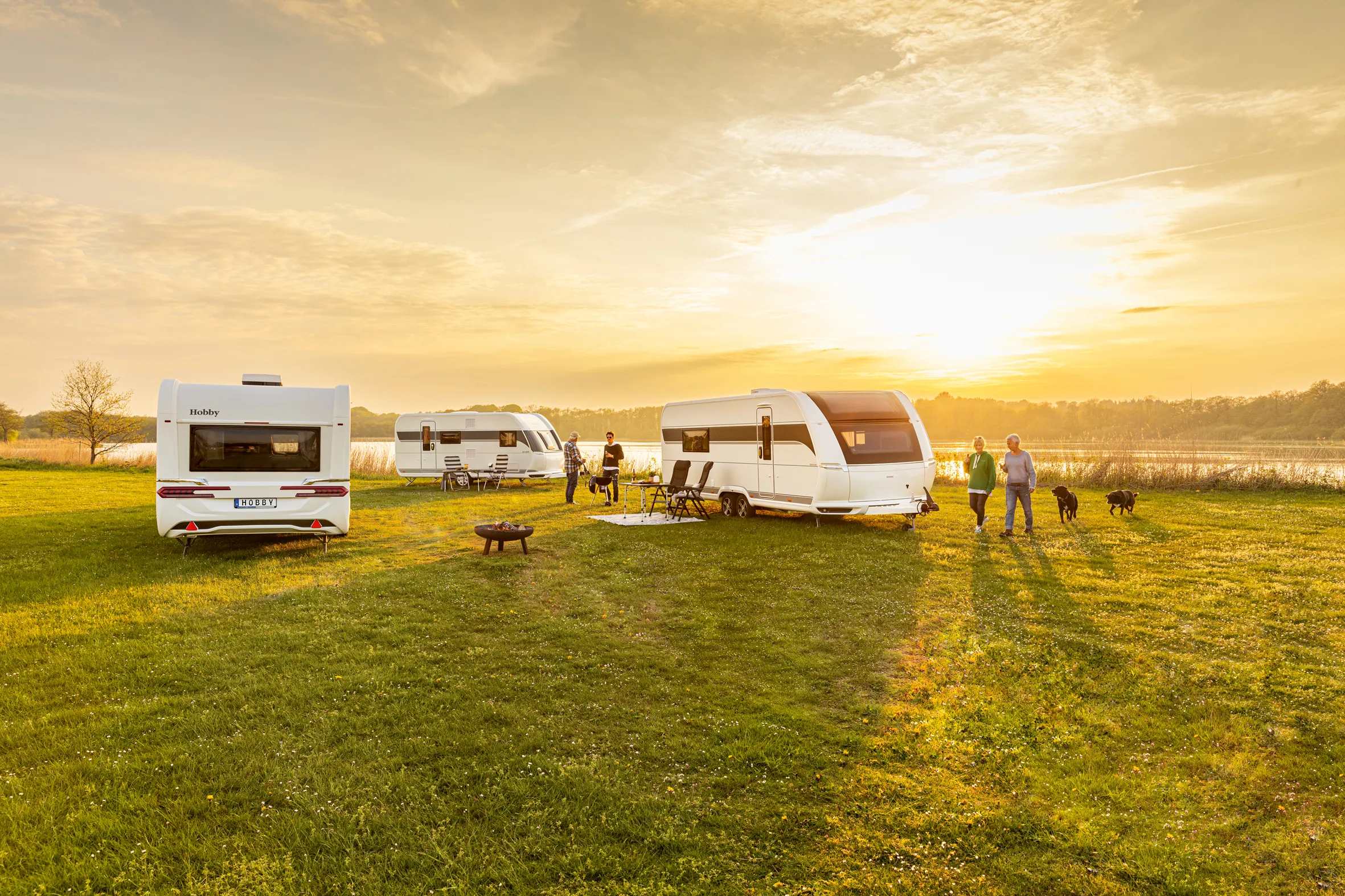 Hobby Wohnwagen auf einer Wiese bei Sonnenuntergang