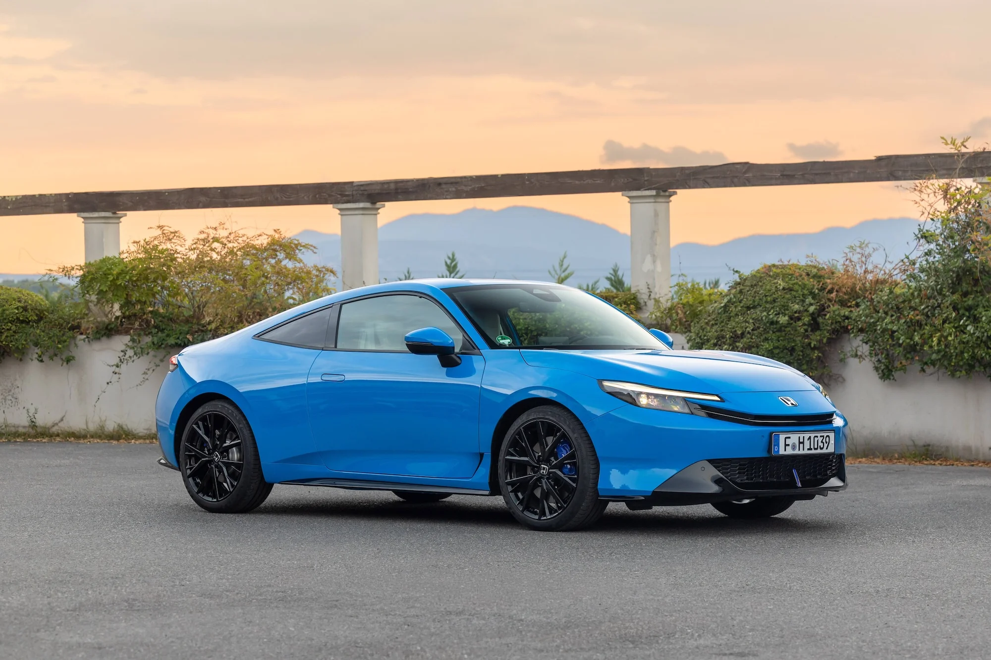 Honda Poly in blau stehend vor einer Brücke, Seitenansicht von rechts