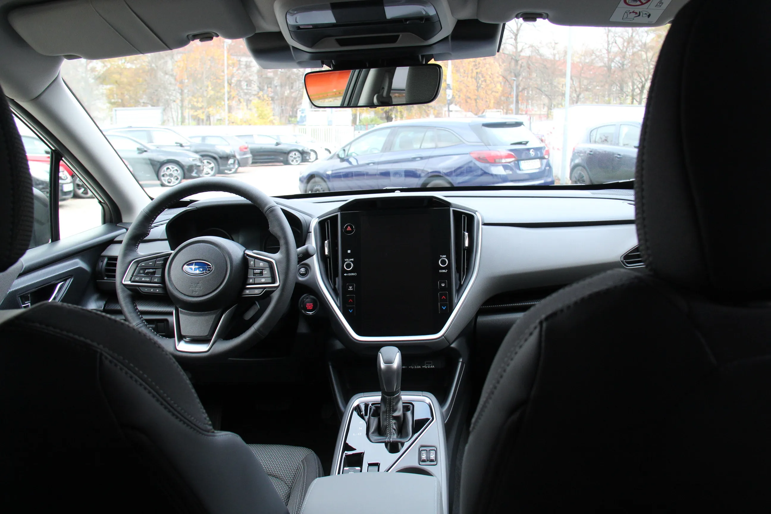 Innenansicht eines Subaru mit Lenkrad, großem Touchdisplay und Automatikschaltung.