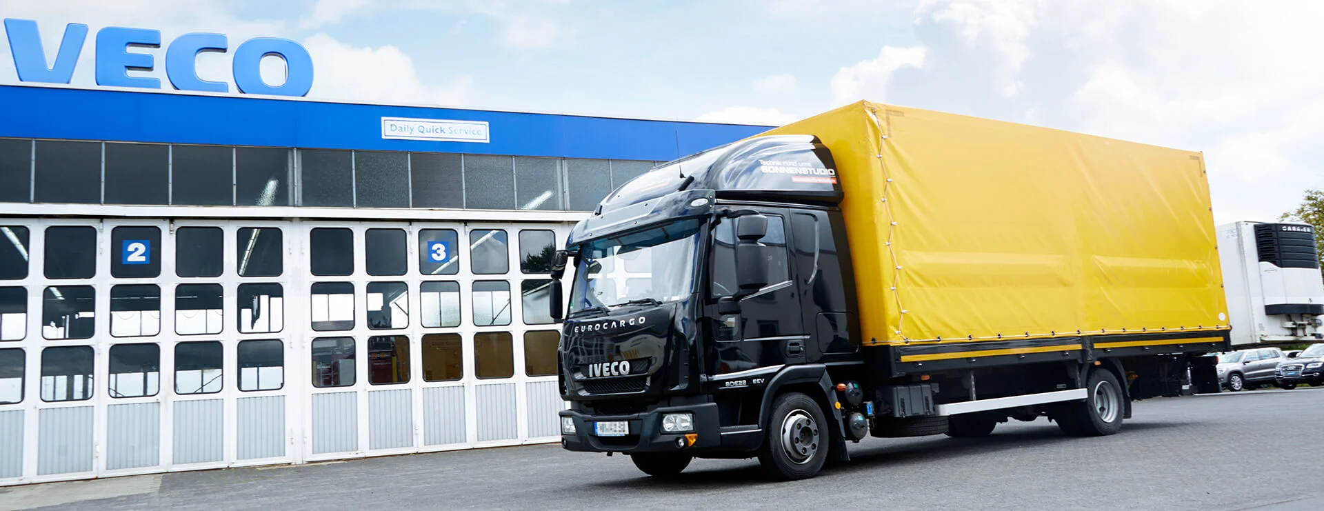 Iveco LKW in schwarz mit gelben planen Aufbau vor der Autozentrale Sturm.