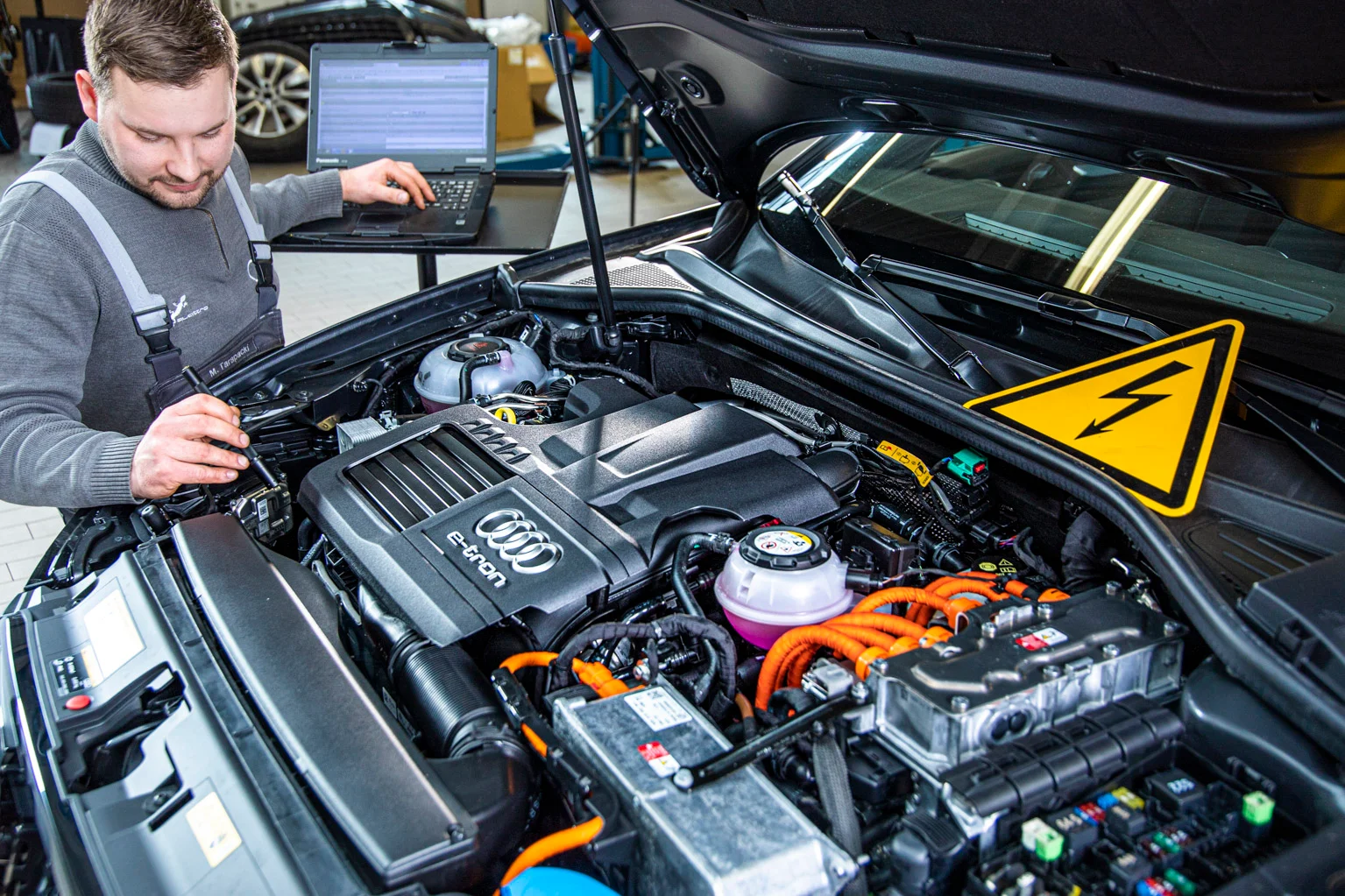 Kfz Mechatroniker bei der Überprüfung der Fahrbatterie