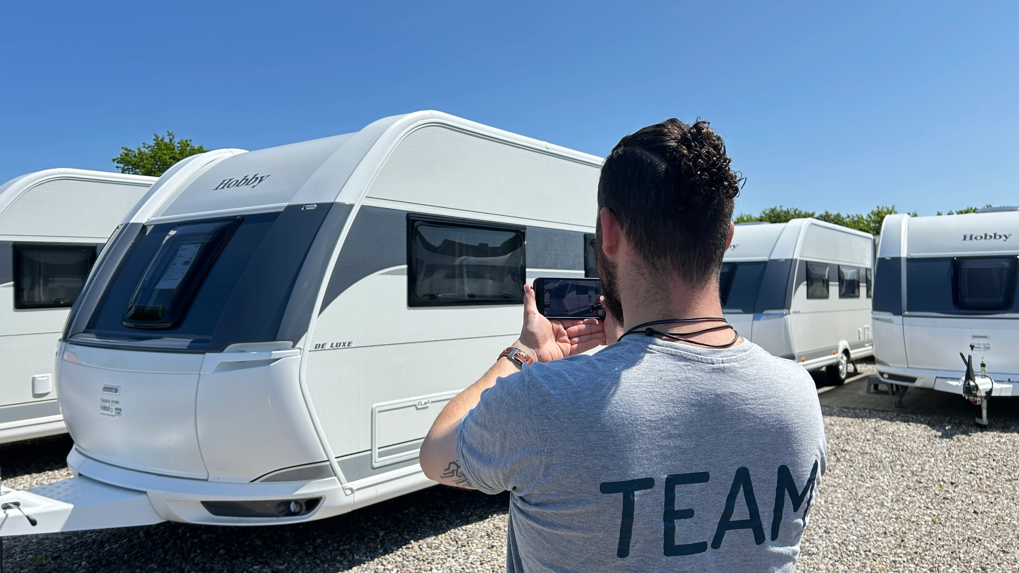 Verkaufsberater bei einem Video-Anruf vor einem Hobby Wohnwagen