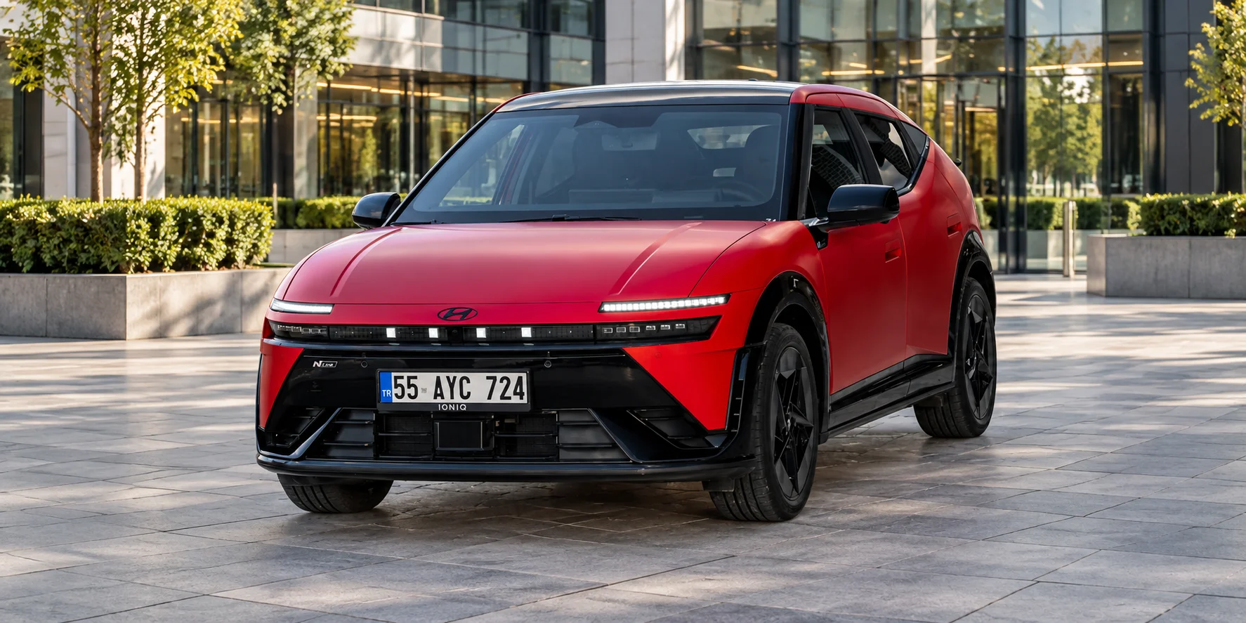 Roter Hyundai IONIQ 5 vor moderner Glasfassade.png Dieses Bild wurde mit KI generiert oder bearbeitet