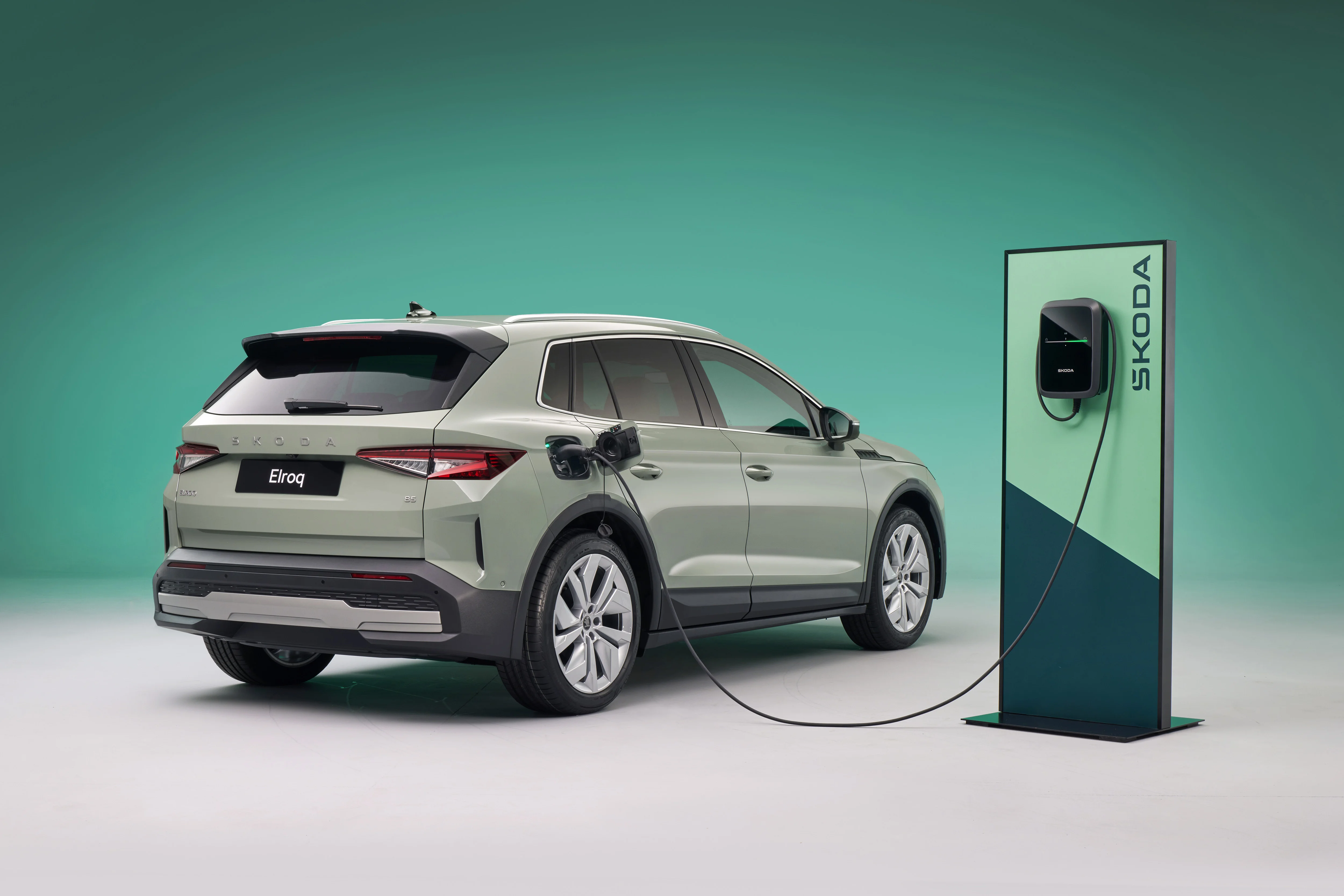 Der Skoda Elroq steht im 30 Grad Winkel weggerichtet vom Betrachter an einer Ladesäule