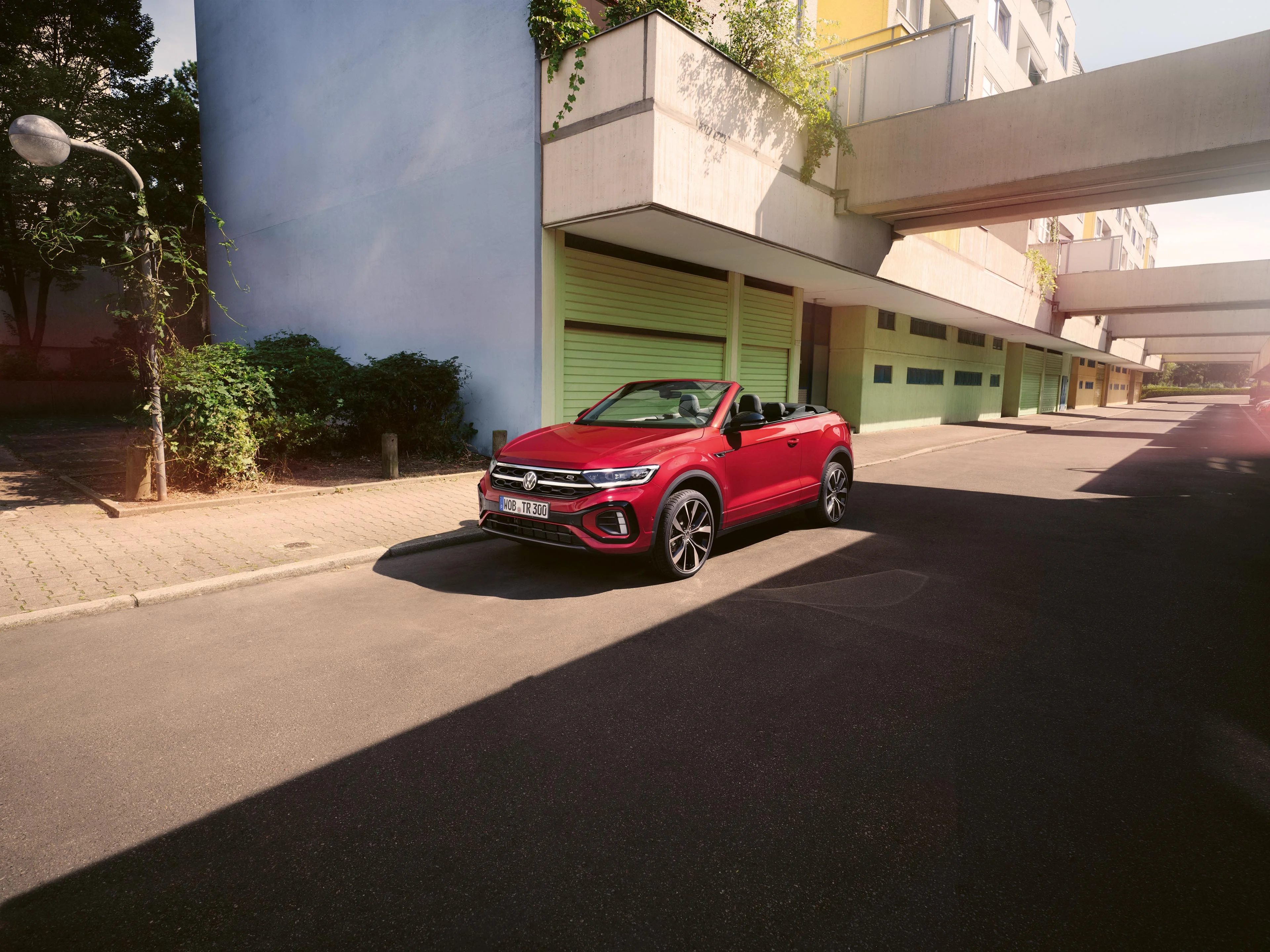 Rotes T-Roc Cabriolet parkt an der Straßenseite vor urbaner Umgebung