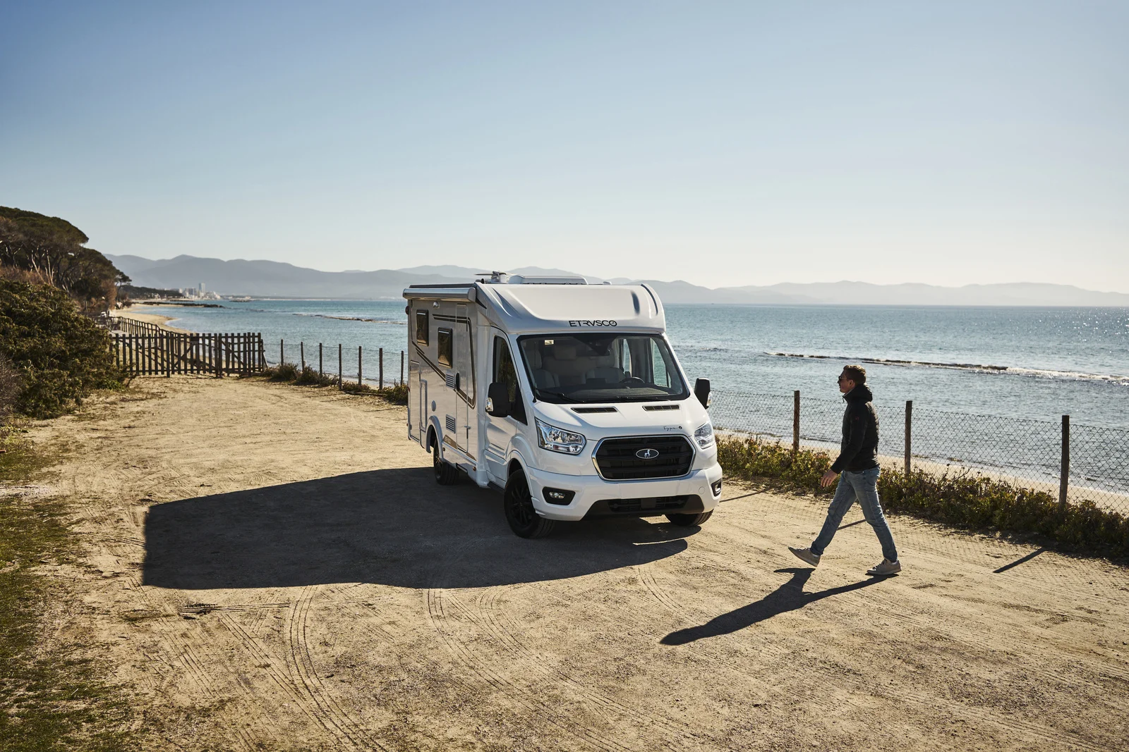 Teilintegriertes Etrusco Wohnmobil auf Ford-Basis an der Küste: modernes Reisemobil am Meer mit freiem Blick auf Strand und Wasser, ideal für komfortables Camping und Roadtrips.
