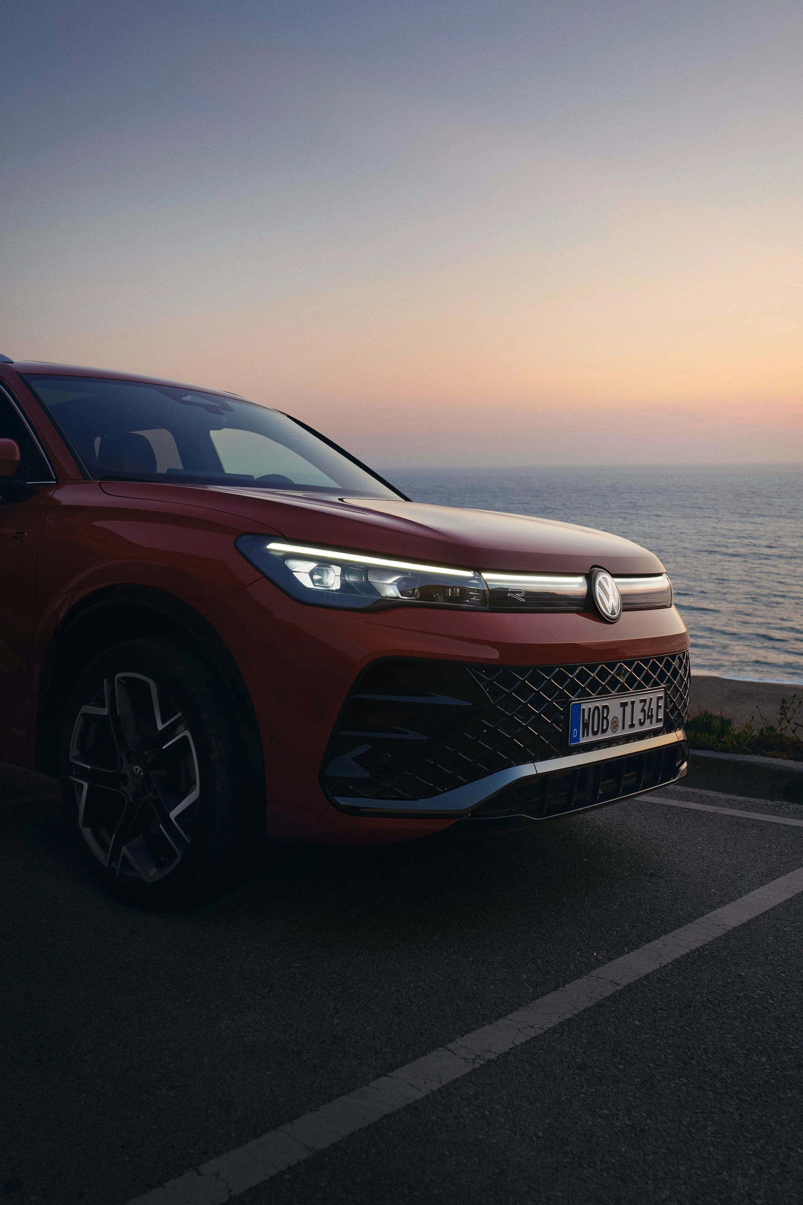 Detailansicht: Roter Tiguan vor Sonnenuntergang mit Scheinwerferlicht