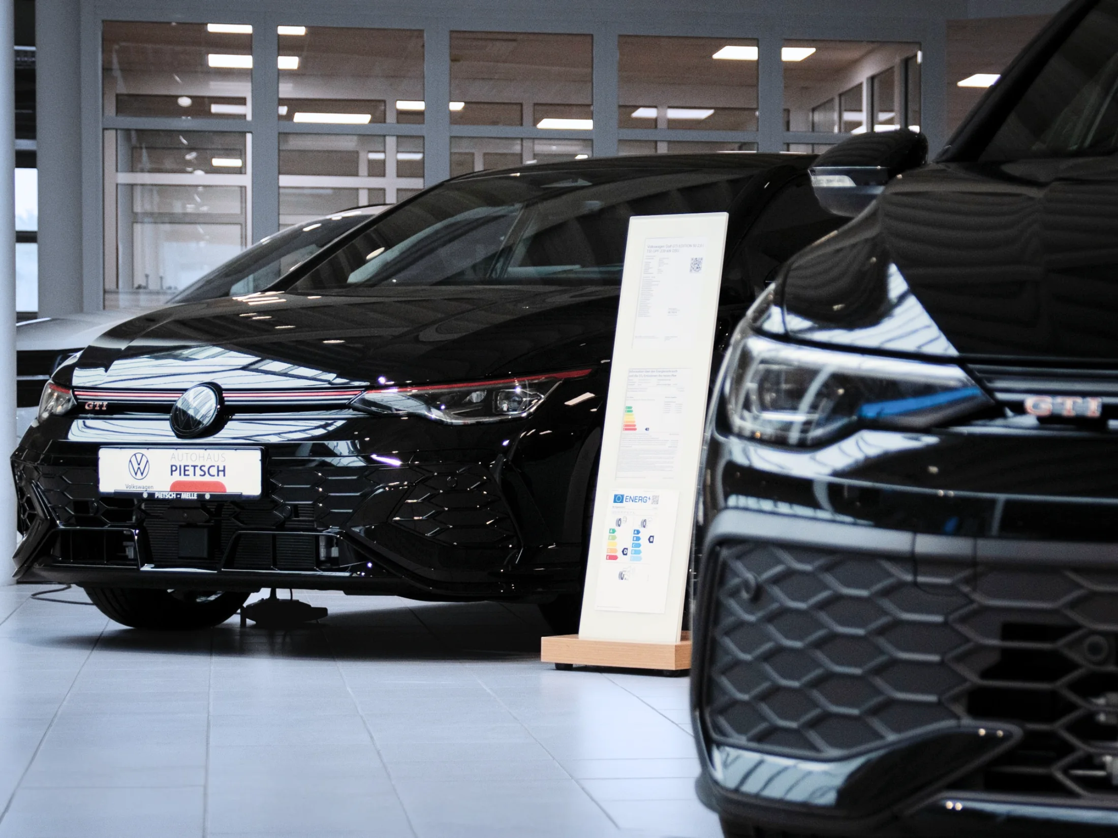 Zwei schwarze Golf GTI im Showroom